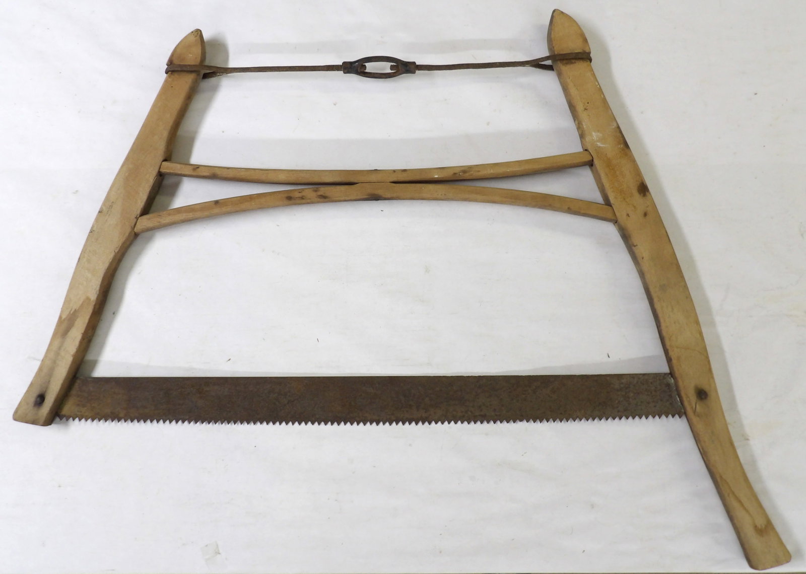 Antique Wooden Primitive Buck Saw: This antique primitive-style buck saw featutres an H-frame and turnbuckle tension rod, and was used to cut logs. Measures approx. 26" x 31". NO SHIPPING ON THIS ITEM
