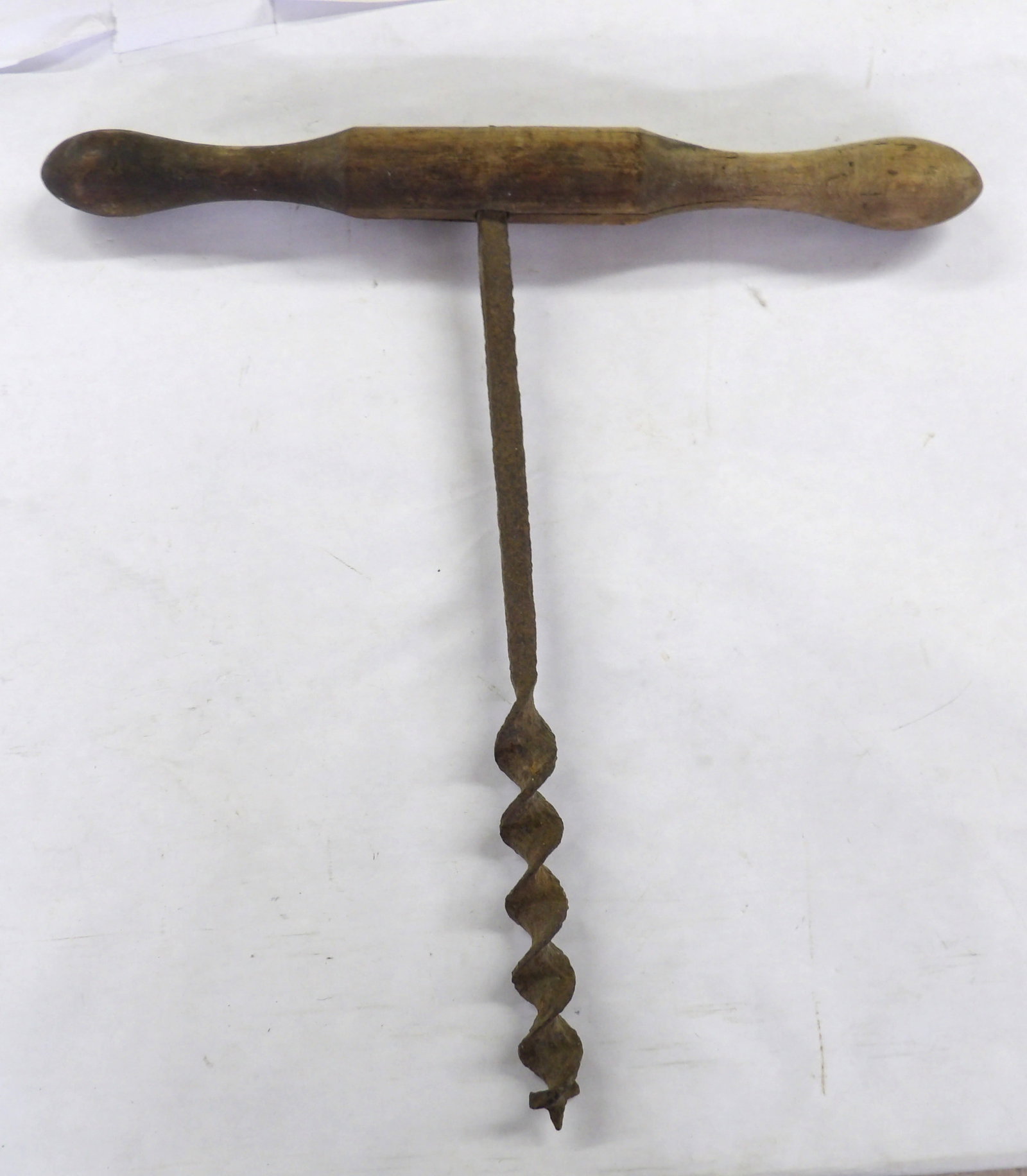 Antique T-handle Wood Auger: This antique T-handle wood auger, a manual drilling tool commonly used in the 19th and early 20th centuries, consists of a T-shaped wooden handle perpendicular to a rotating iron shaft and was