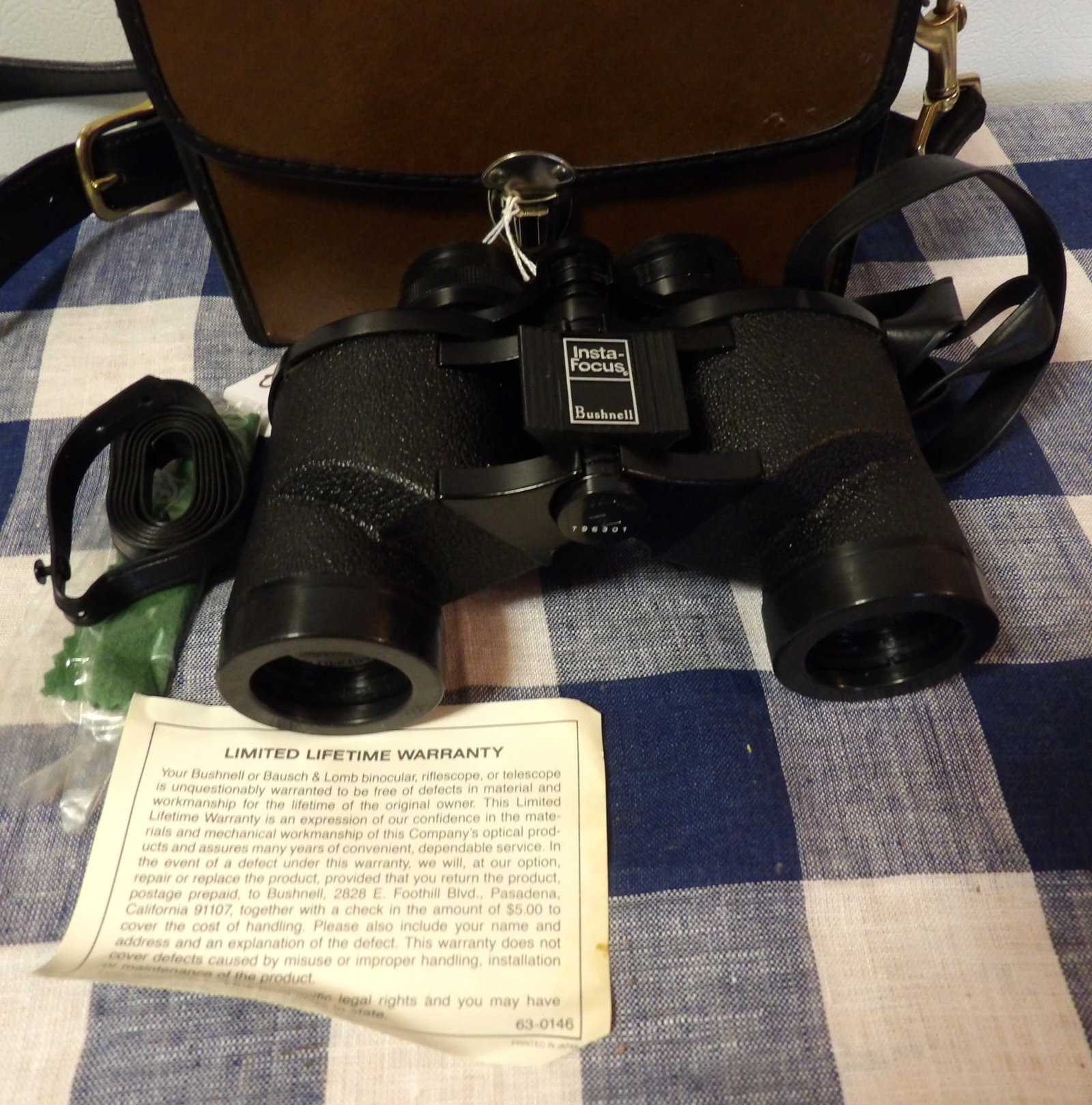 Insta Focus Bushnell Binoculars w/ carrying case: This pair of Insta Focus Bushnell Binoculars includes leather case w carrying strap "T96301". Measures 7.5" x 5.5" x 2.75"