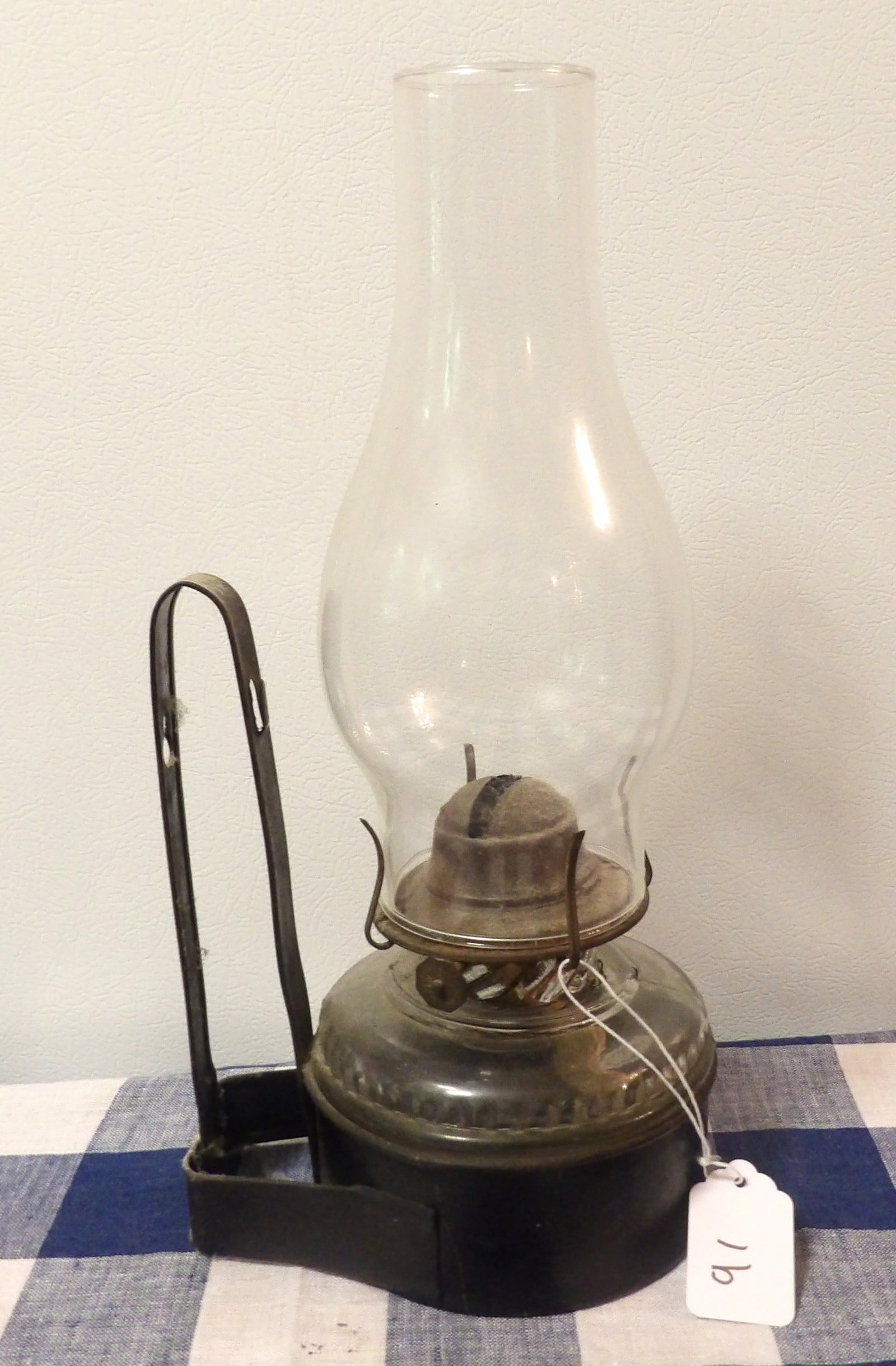 Wall Mounted Oil Lamp: This antique oil lamp features a metal mounting bracket and a clear glass chimney. Measures 13" x 5"