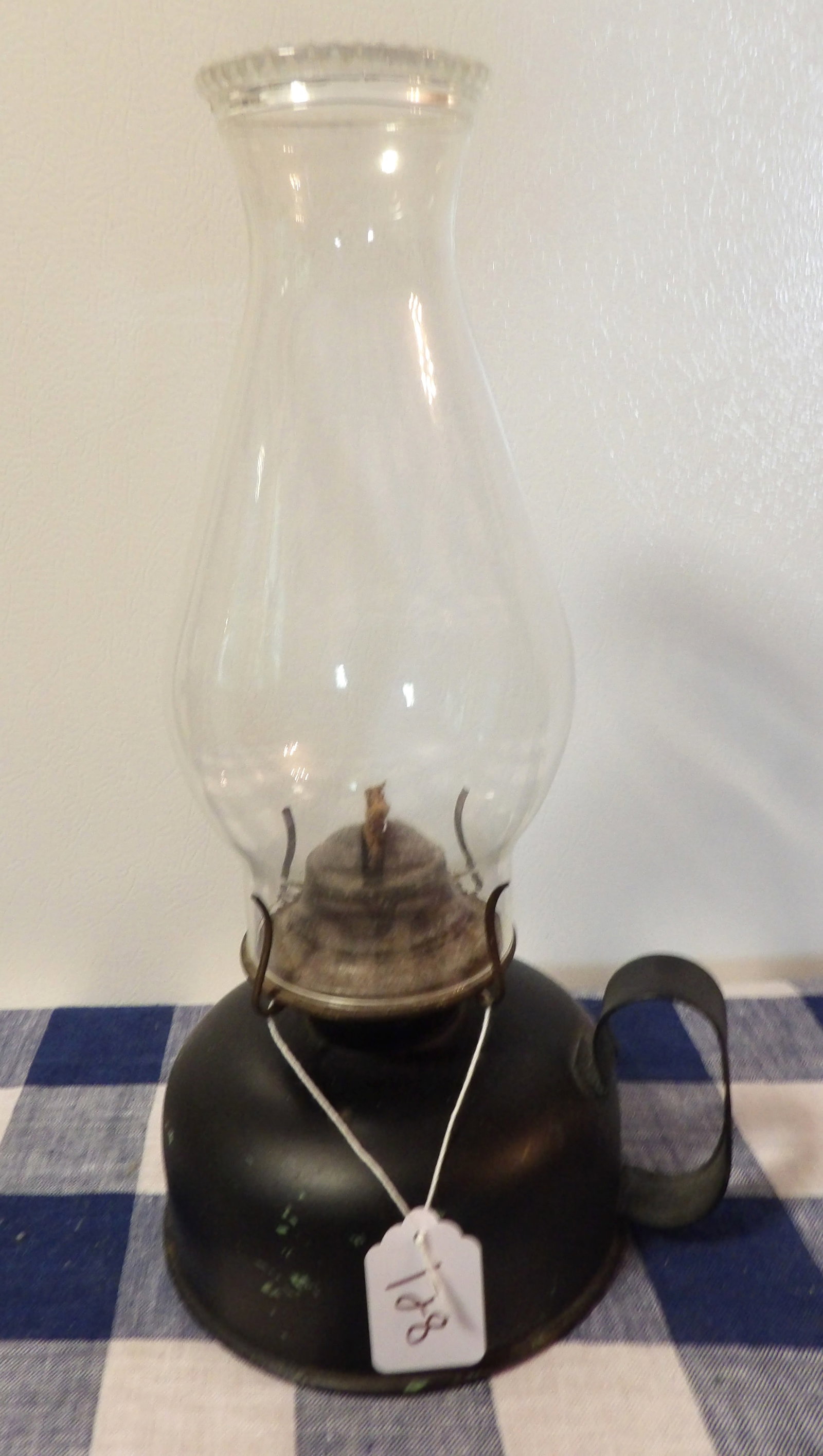 Antique Oil Lamp: This antique oil lamp features a metal base and a glass chimney. Measures 13" x 8"