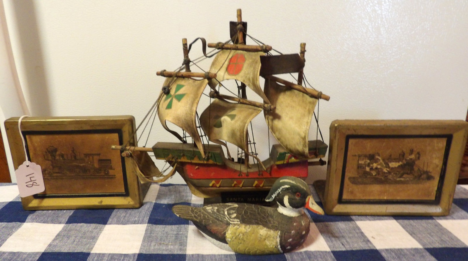 Locomotive Book Ends, Santa Maria Ship, Wood Duck Sculpture: This lot includes a pair of Locomotive Book Ends, a Santa Maria Ship, and a Wood Duck Sculpture. Measures 5" x 6", 10" x 10" x 3"