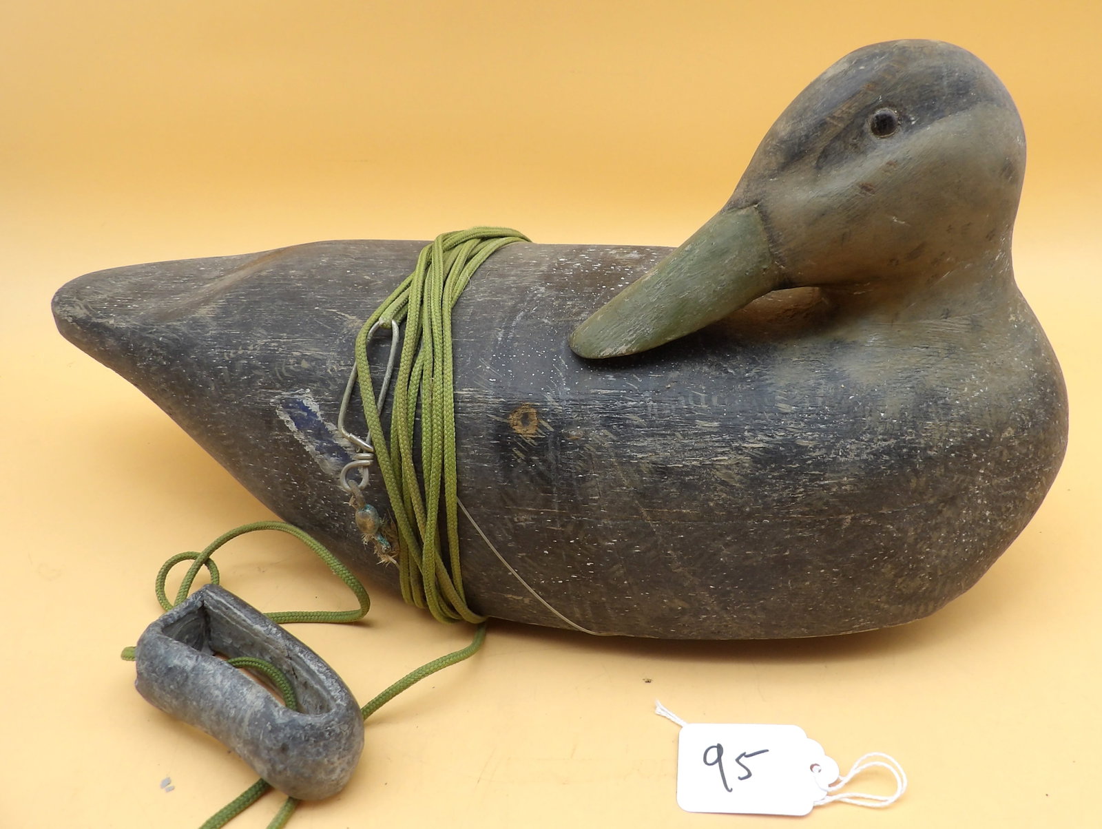 "American Black Duck" Wood Carved Metzger Decoy: This detailed wood carved duck decoy was created by renowned area decoy artist Lawrence Metzger. Includes lead line and weight. Measures approx: 8" x 14" x 6"