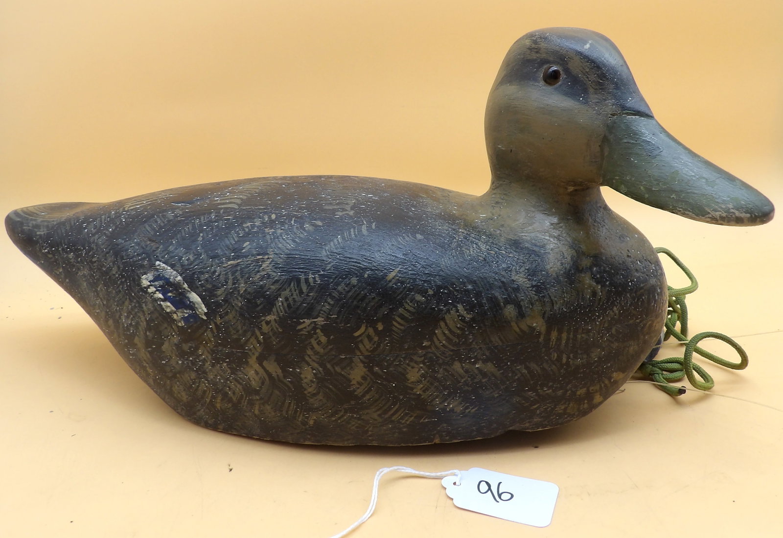 "American Black Duck" Wood Carved Metzger Decoy: This detailed wood carved decoy was created by renowned area decoy artist Lawrence Metzger. Includes lead line and weight. Measures approx: 7" x 15.5" x 6.5"