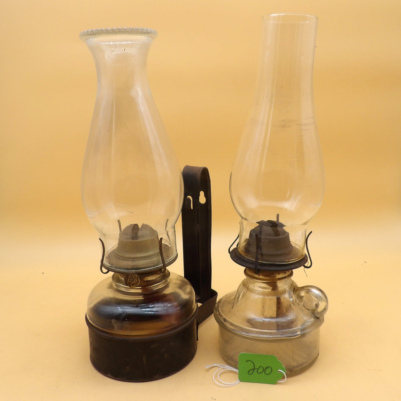 Vintage Oil Lamps (2): This pair of vintage glass oil lamps includes one that is wall-mountable and one that is carried. Measures approx: 13" each. NO SHIPPING AVAILABLE FOR THIS ITEM - PICK UP ONLY