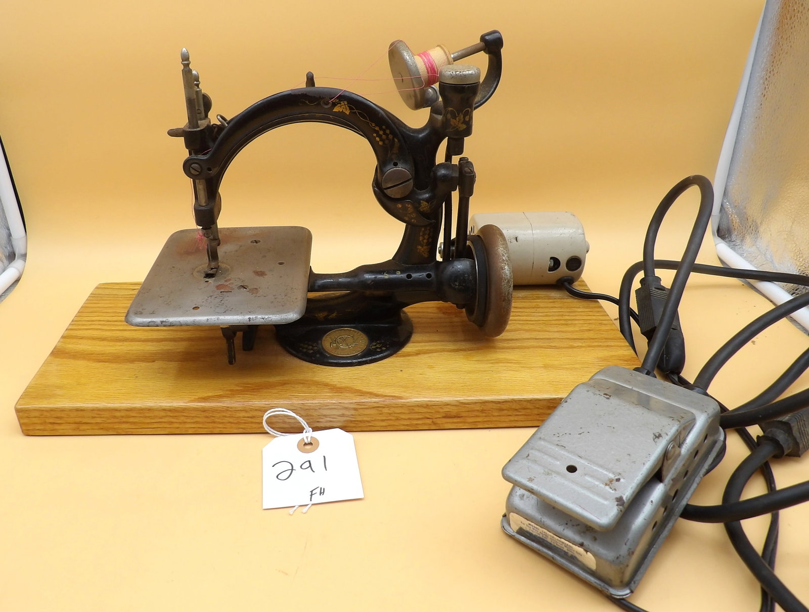 Wilcox & Gibbs Chain Stitch Sewing Machine: This antique Wilcox & Gibbs chain stitch sewing machine is retrofitted with an electric motor (works) and mounted on a wooden board. Includes foot pedal. Measures approx: 10" x 17" x 7" . NOTE -