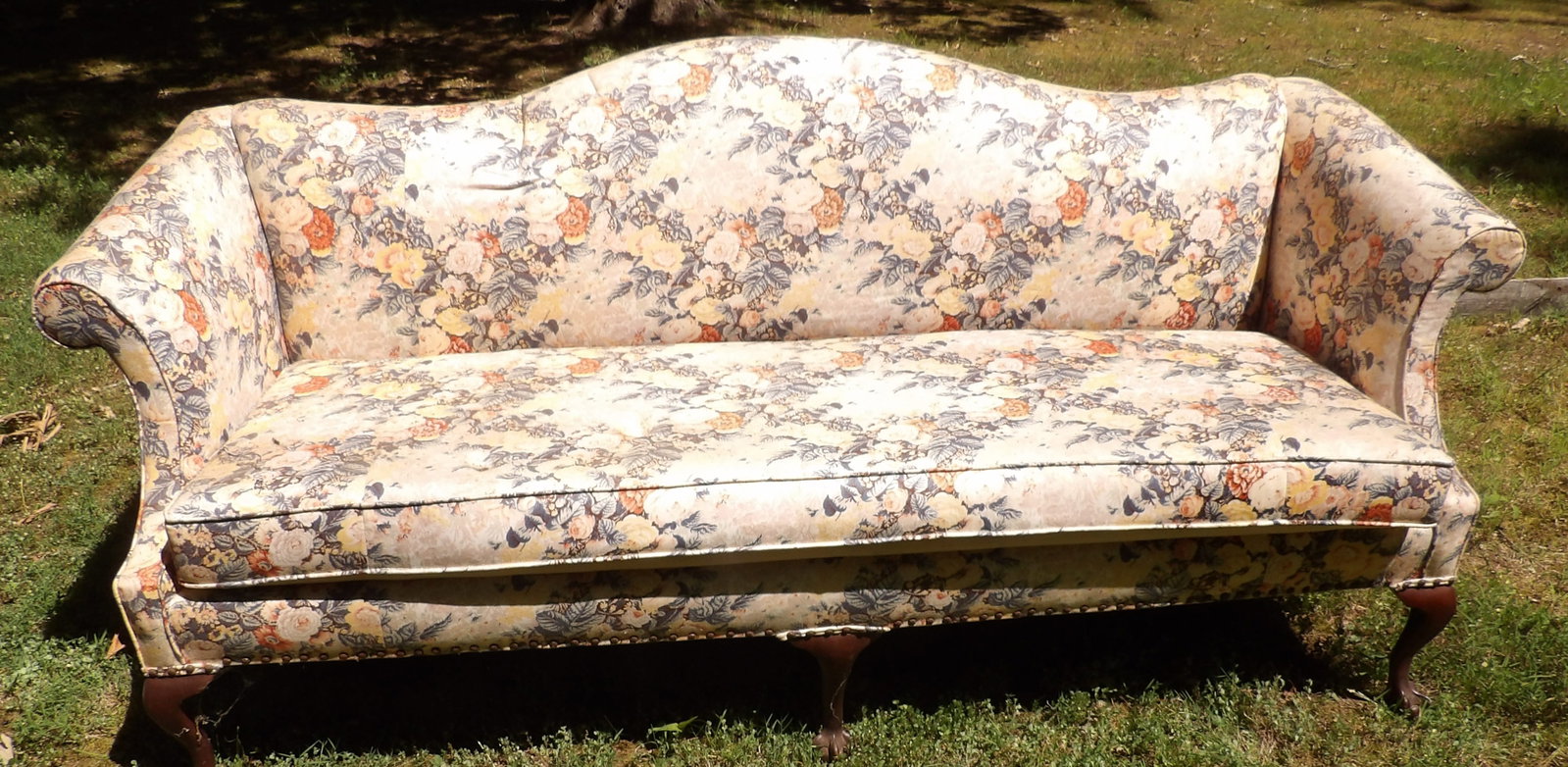 Floral Camelback Sofa: This lot features a lovely traditional floral camelback sofa with floral upholstery and ornate clawed wooden legs. NO SHIPPING ON THIS ITEM - PICK UP ONLY