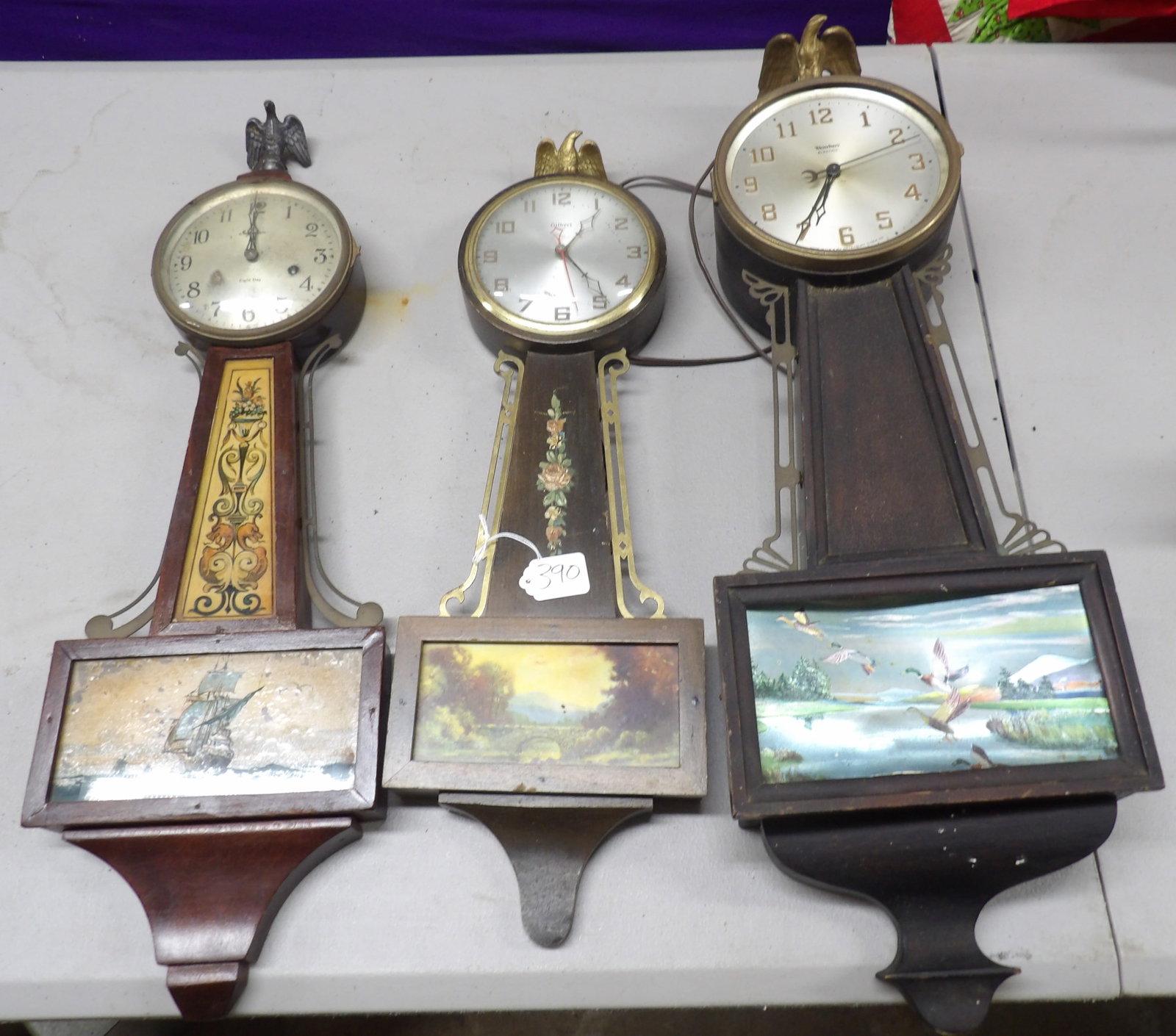 Banjo Style Wall Clocks (3): This trio of vintage banjo-style wall clocks are not in "needs repair" or "for parts" condition, but are intact with vibrant scenes. Ingrahm, Gilbert (electric), and Waterbury (electric). NO SHIPPING 