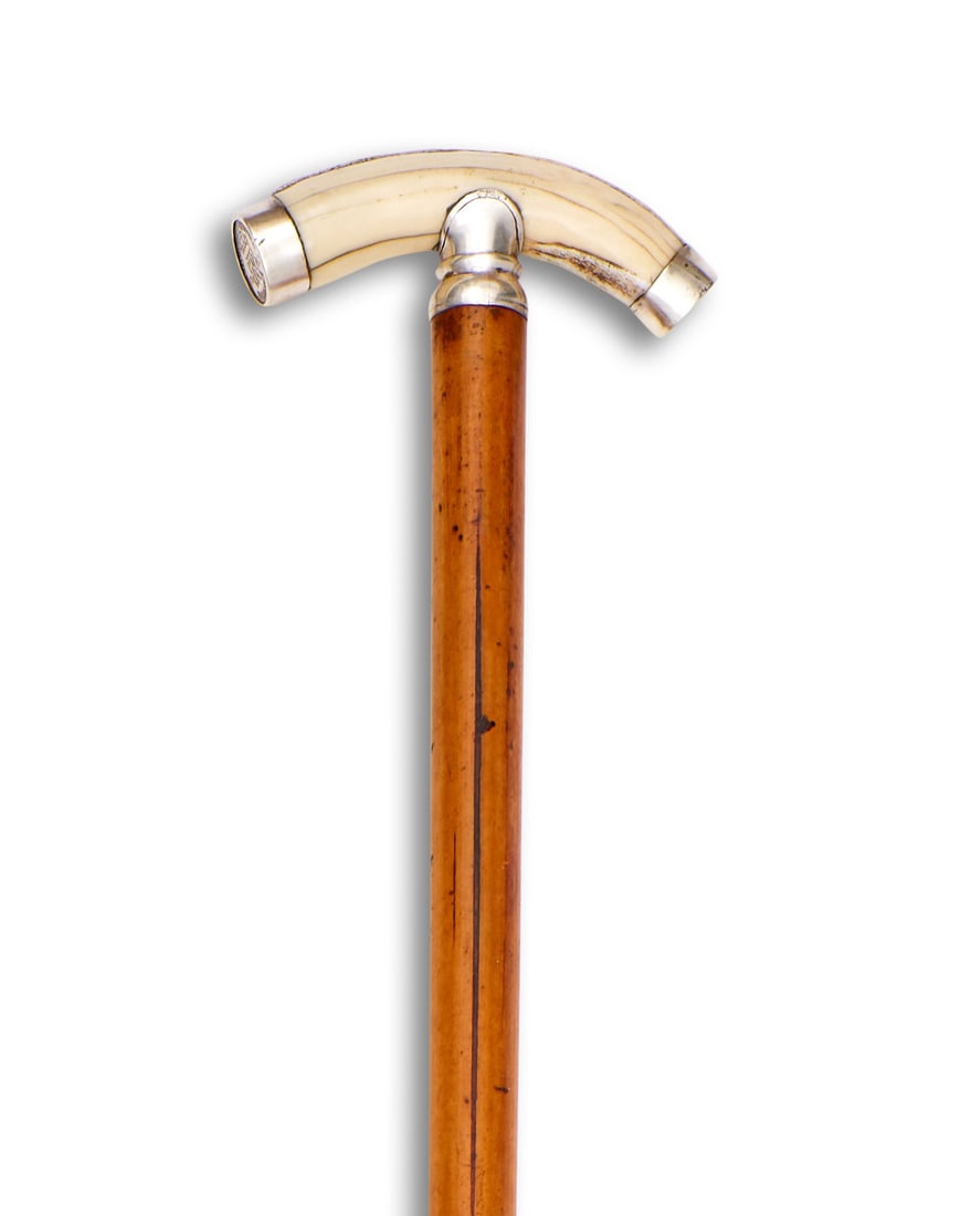 A WALKING CANE WITH BOAR TUSK AND 1943 SIX PENCE MOUNTED HANDLE: A WALKING CANE WITH BOAR TUSK AND 1943 SIX PENCE MOUNTED HANDLE A WALKING CANE WITH BOAR TUSK AND 1943 SIX PENCE MOUNTED HANDLE the novely cane with handle carved from a boar's tusk, mounted with a co