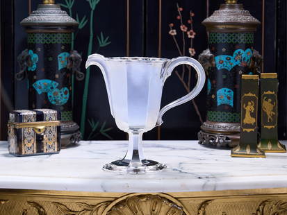 OMAR RAMSDEN C. 1932: A LARGE STERLING SILVER JUG: OMAR RAMSDEN C. 1932: A LARGE STERLING SILVER JUG The early 20th century silver water or cocktail pitcher in the Arts and Crafts style, with faceted body and scroll handle, raised on a faceted spreadi