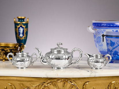 A LATE 19TH CENTURY CHINESE EXPORT SILVER TEA SET: A LATE 19TH CENTURY CHINESE EXPORT SILVER TEA SET comprising a teapot, sugar bowl and milk jug, each with handles imitating bamboo, decorated with prunus blossom, marked to underside LW, for retailer