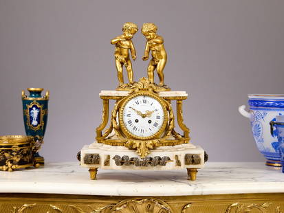 A 19TH CENTURY FRENCH ORMOLU AND MARBLE CLOCK BY RAINGO FRERES, PARIS: A 19TH CENTURY FRENCH ORMOLU AND MARBLE CLOCK BY RAINGO FRERES, PARIS the mantel clock decorated with a pair of gilt bronze putti over the white marble plinth base, the white enamelled dial with Roman