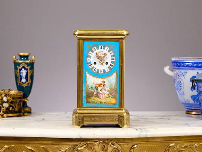A FINE LATE 19TH CENTURY SEVRES STYLE PORCELAIN AND ORMOLU MANTEL CLOCK: A FINE LATE 19TH CENTURY SEVRES STYLE PORCELAIN AND ORMOLU MANTEL CLOCK the French gilt bronze case with porcelain panels to the sides depicting an exotic bird carrying a basket of flowers, with a gil