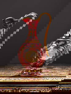 A LATE 19TH CENTURY BOHEMIAN GLASS EWER FOR THE ISLAMIC MARKET: A LATE 19TH CENTURY BOHEMIAN GLASS EWER FOR THE ISLAMIC MARKET the ruby glass jug for the Persian or Ottoman market, with scroll handle on circular foot, with red flashed decoration and enamelled with