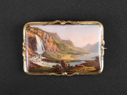 AN EARLY 19TH CENTURY SWISS ENAMEL AND 18CT GOLD BROOCH: AN EARLY 19TH CENTURY SWISS ENAMEL AND 18CT GOLD BROOCH the enamel finely painted with a scene of a waterfall cascading from mountains, the gold brooch with applied ribbons, with pin to the reverse, u