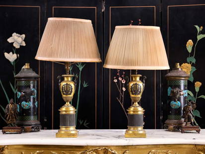 A PAIR OF 19TH CENTURY FRENCH EMPIRE STYLE GILT AND PATINED BRONZE URN LAMPS: A PAIR OF 19TH CENTURY FRENCH EMPIRE STYLE GILT AND PATINED BRONZE URN LAMPS the ormolu urns with applied lyre mounts and a pair of panther head handles, raised on fluted plinths over square bases, la