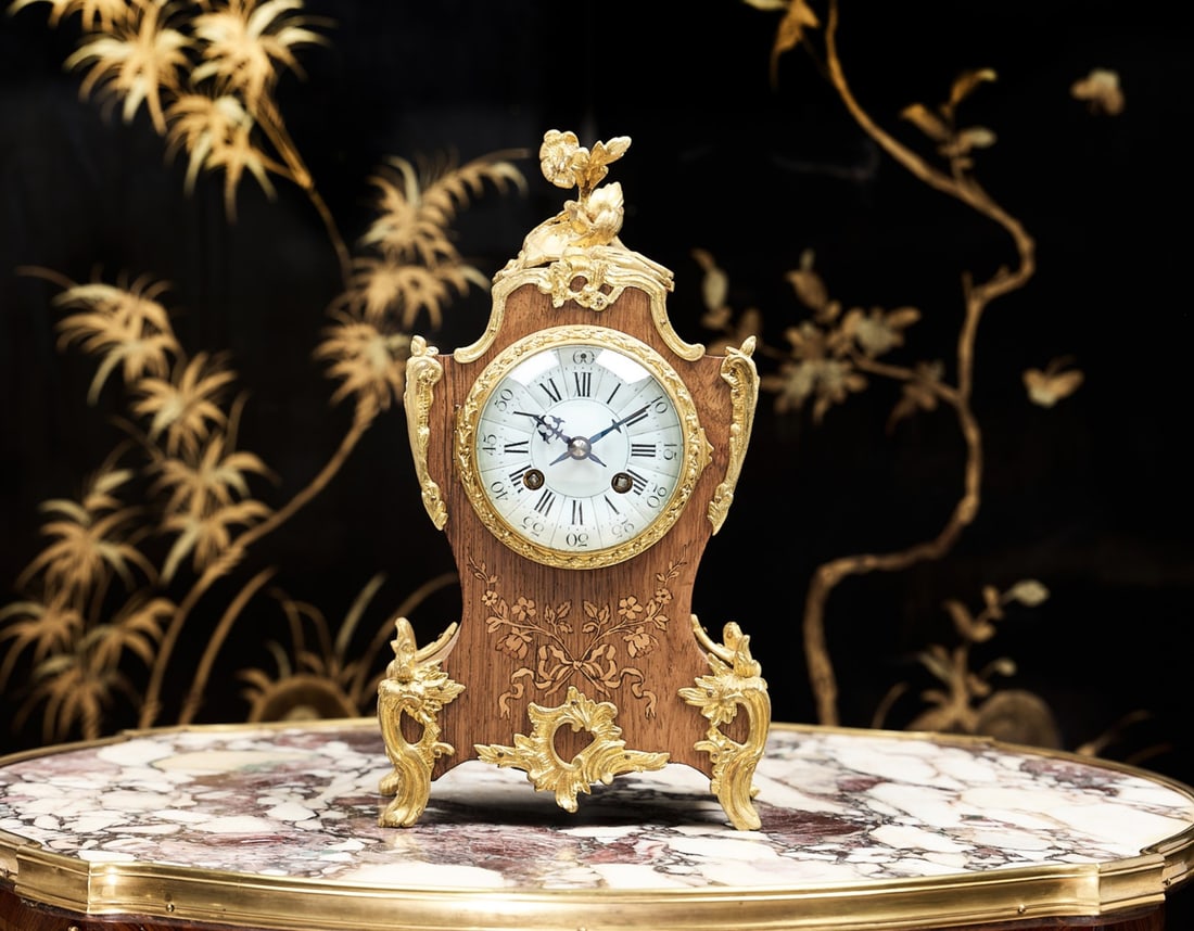 A LATE 19TH / EARLY 20TH CENTURY MARQUETRY AND ORMOLU MOUNTED CLOCK: A LATE 19TH / EARLY 20TH CENTURY MARQUETRY AND ORMOLU MOUNTED CLOCK the French Boulle style mantel clock in the 18th century taste, with gilt bronze Rococo mounts, the case of shaped waisted outline,