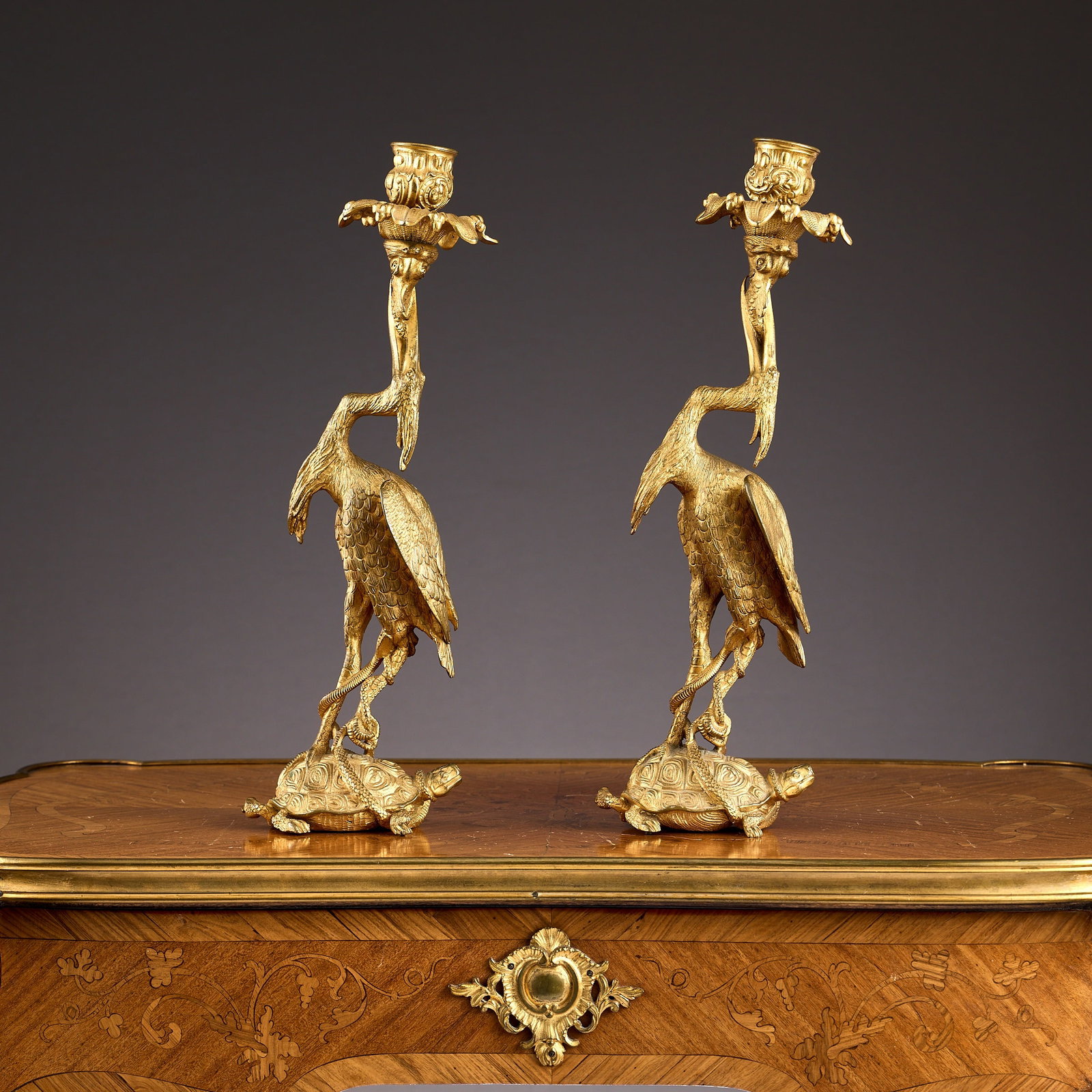 A PAIR OF 19TH CENTURY ORMOLU CANDLESTICKS AFTER THOMAS ABBOT: A PAIR OF 19TH CENTURY ORMOLU CANDLESTICKS AFTER THOMAS ABBOT probably Regency, the gilt bronze candlesticks modelled as storks or cranes raised on the backs of tortoises, holding urn shaped candle no