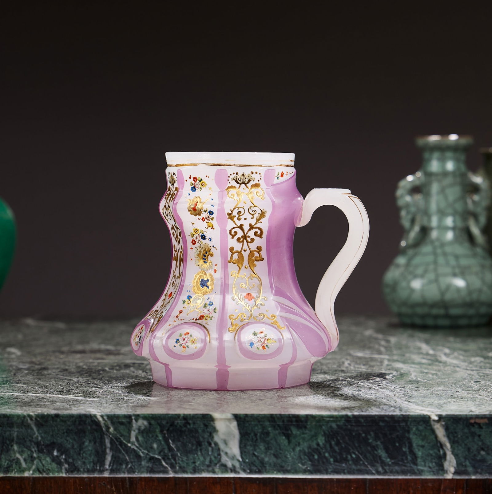 A MID 19TH CENTURY BOHEMIAN ENAMELLED GLASS MUG FOR THE OTTOMAN MARKET: A MID 19TH CENTURY BOHEMIAN ENAMELLED GLASS MUG FOR THE OTTOMAN MARKET the cup or mug with faceted sides on octagonal foot and with faceted handle, decorated with six ovals with floral decoration, the