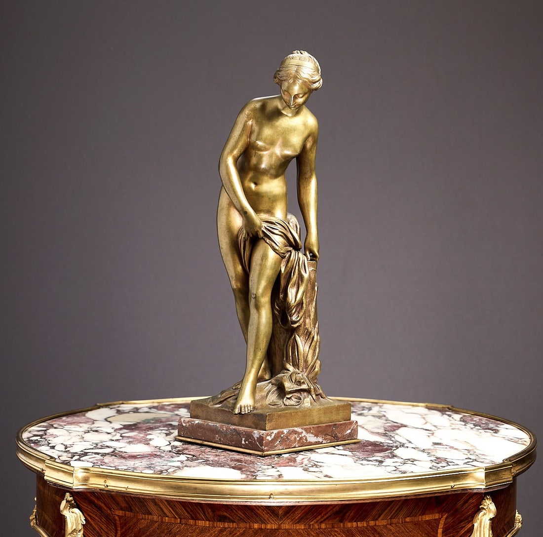 A 19TH CENTURY BRONZE OF VENUS AFTER THE BATH AFTER FALCONET: A 19TH CENTURY BRONZE OF VENUS AFTER THE BATH AFTER FALCONET the gilt bronze figure depicting the nude Venus on a naturalistic base, over a breccia marble plinth, 43cm high