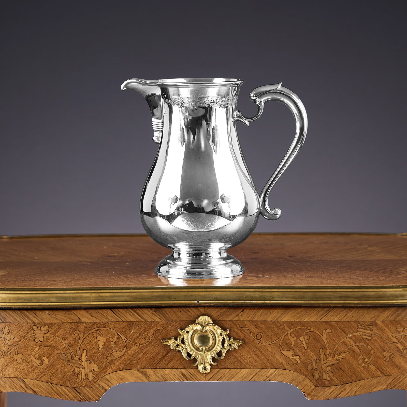 GARRARD & CO.: A STERLING SILVER WATER PITCHER: GARRARD & CO.: A STERLING SILVER WATER PITCHER the large beer jug or pitcher with scroll handle and stepped circular foot, with trellis work border to the neck, hallmarked London, 1982, maker's ma