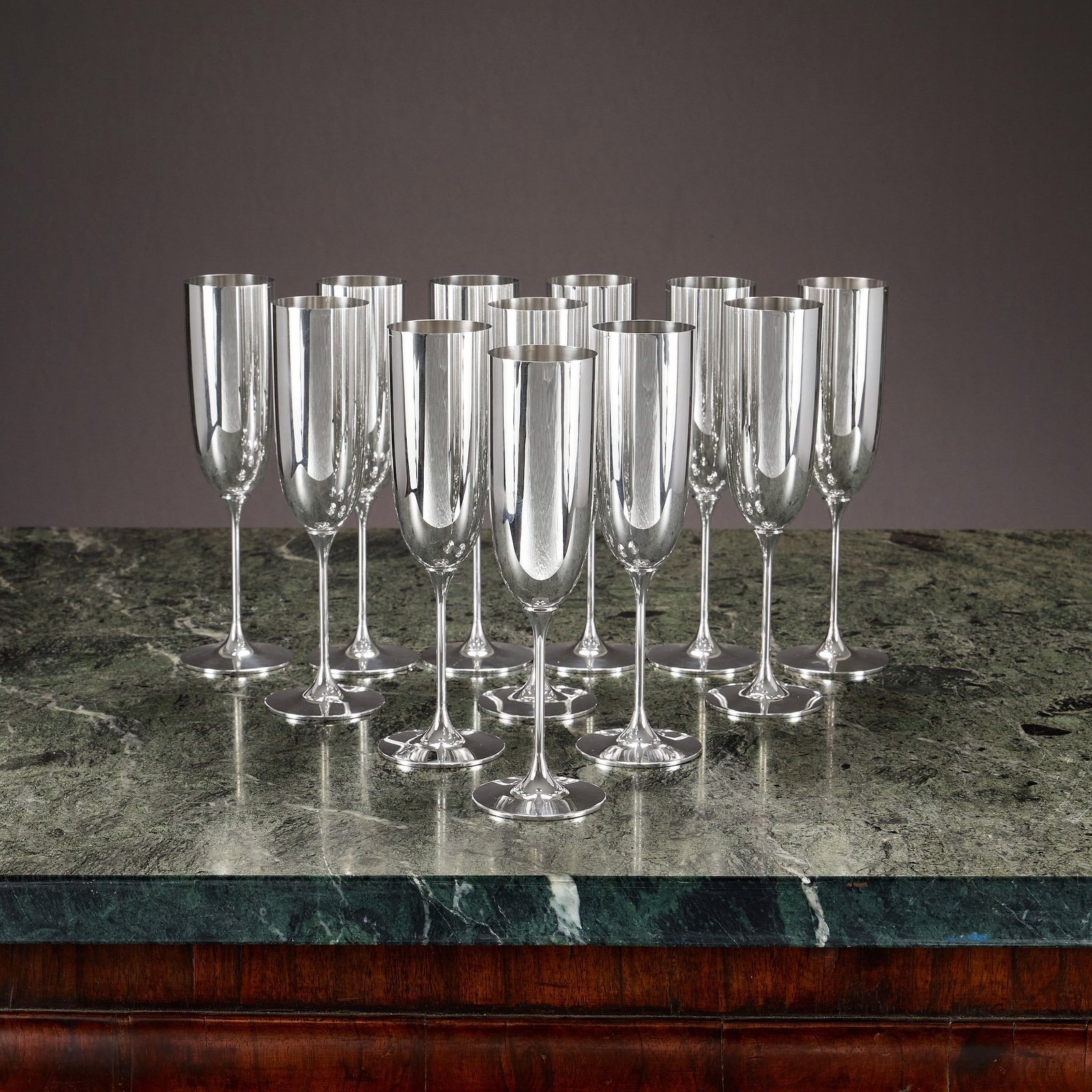 A SET OF TWELVE STERLING SILVER CHAMPAGNE FLUTES: A SET OF TWELVE STERLING SILVER CHAMPAGNE FLUTES 20th century, German, on narrow stems and circular feet, marked with German crescent moon and crown mark, 925 for sterling and R&B, 2900g (93.23 oz