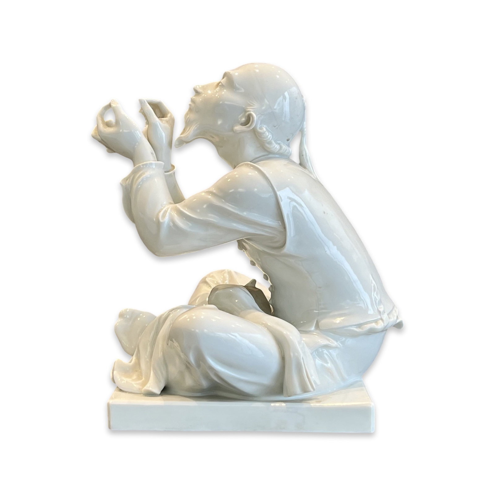 MEISSEN: A BLANC DE CHINE PORCELAIN FIGURE OF A CHINESE TAILOR: MEISSEN: A BLANC DE CHINE PORCELAIN FIGURE OF A CHINESE TAILOR Tailor Wibbel after Alexander Struck, the seated figure on a square base, with blue crossed swords mark to underside and incised number R