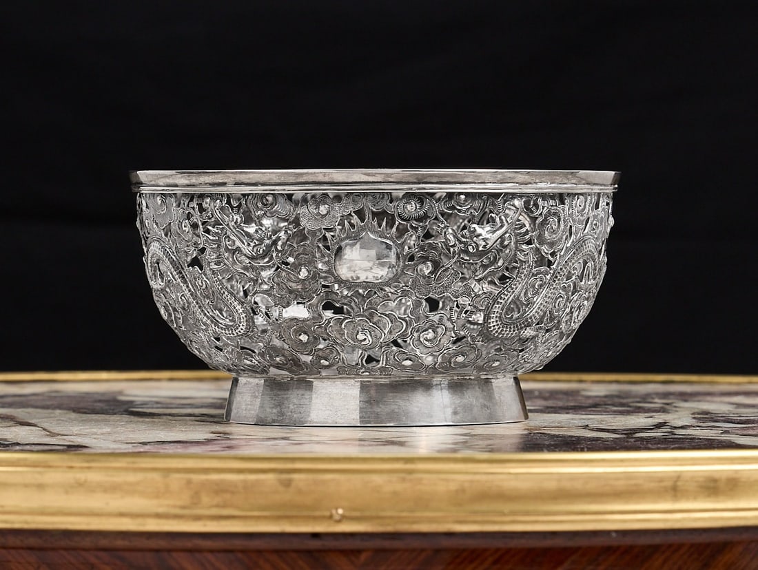 A 19TH CENTURY CHINESE EXPORT SILVER BOWL MARKED FOR WANG HING: A 19TH CENTURY CHINESE EXPORT SILVER BOWL MARKED FOR WANG HING the pierced circular bowl decorated with dragons breathing fire amongst stylised clouds, on a circular foot, marked WH 90 to underside, 3