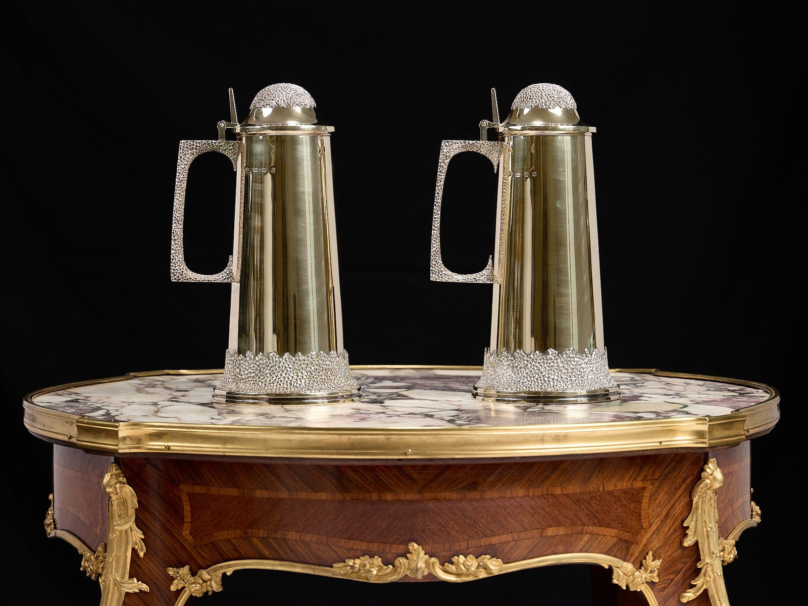 A FINE PAIR OF CHRISTOPHER LAWRENCE STERLING SILVER GILT FLAGONS: A FINE PAIR OF CHRISTOPHER LAWRENCE STERLING SILVER GILT FLAGONS the Modernist Queen Elizabeth II period silver flagons embellished with a textured design to the handles, feet and domed, hinged covers