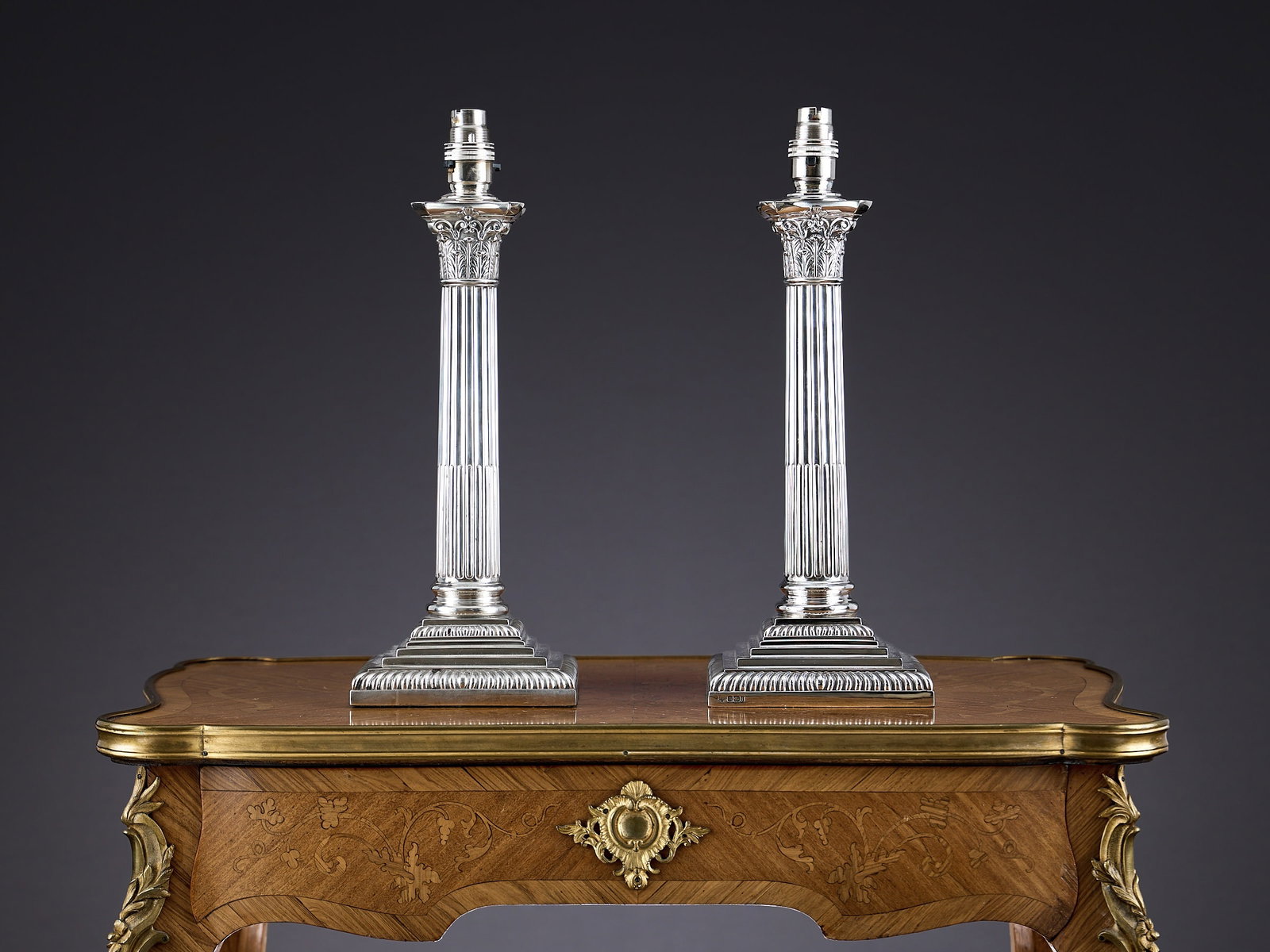 A PAIR OF STERLING SILVER CORINTHIAN COLUMN LAMPS C. 1898,: A PAIR OF STERLING SILVER CORINTHIAN COLUMN LAMPS C. 1898, the late 19th century Victorian lamp bases formed as classical Corinthian columns on square, gadrooned bases, fitted for electricity, hallmar