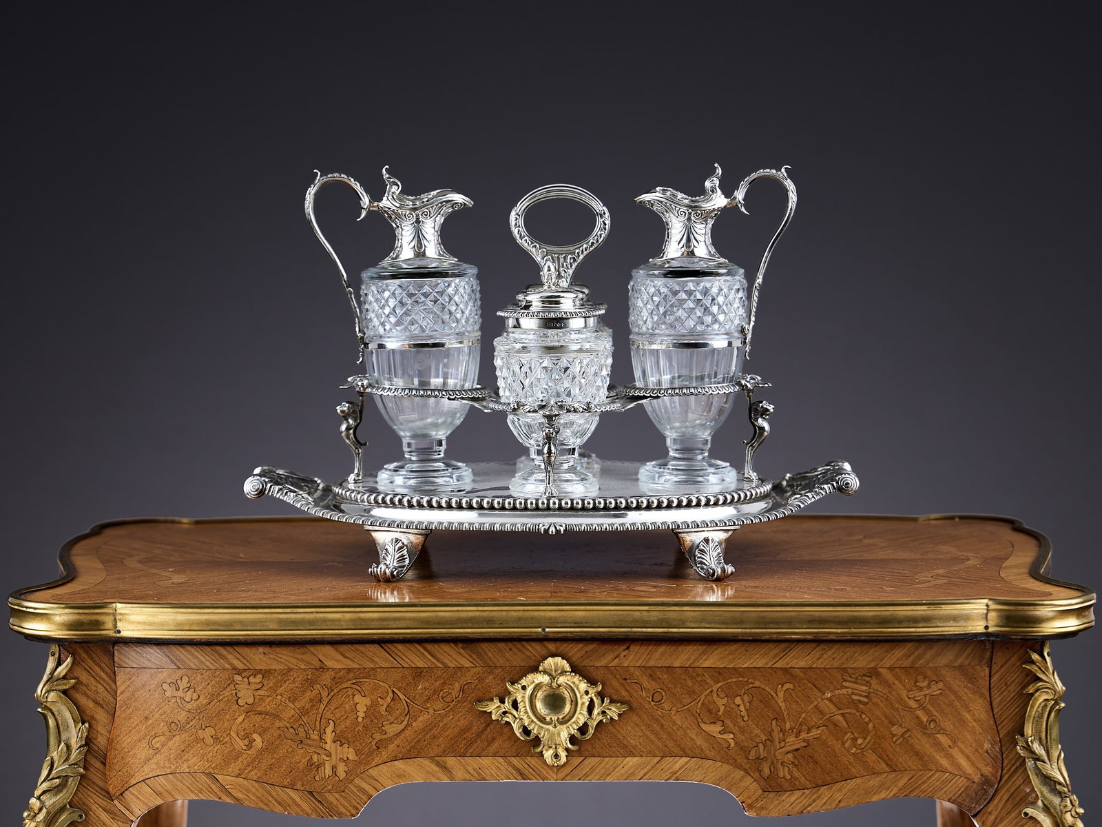 PAUL STORR: A FINE STERLING SILVER AND GLASS CRUET SET C.1808: PAUL STORR: A FINE STERLING SILVER AND GLASS CRUET SET C.1808 George III period / Regency, early 19th century, of impressive size, the large oval stand with gadrooned border and twin foliate and anthe