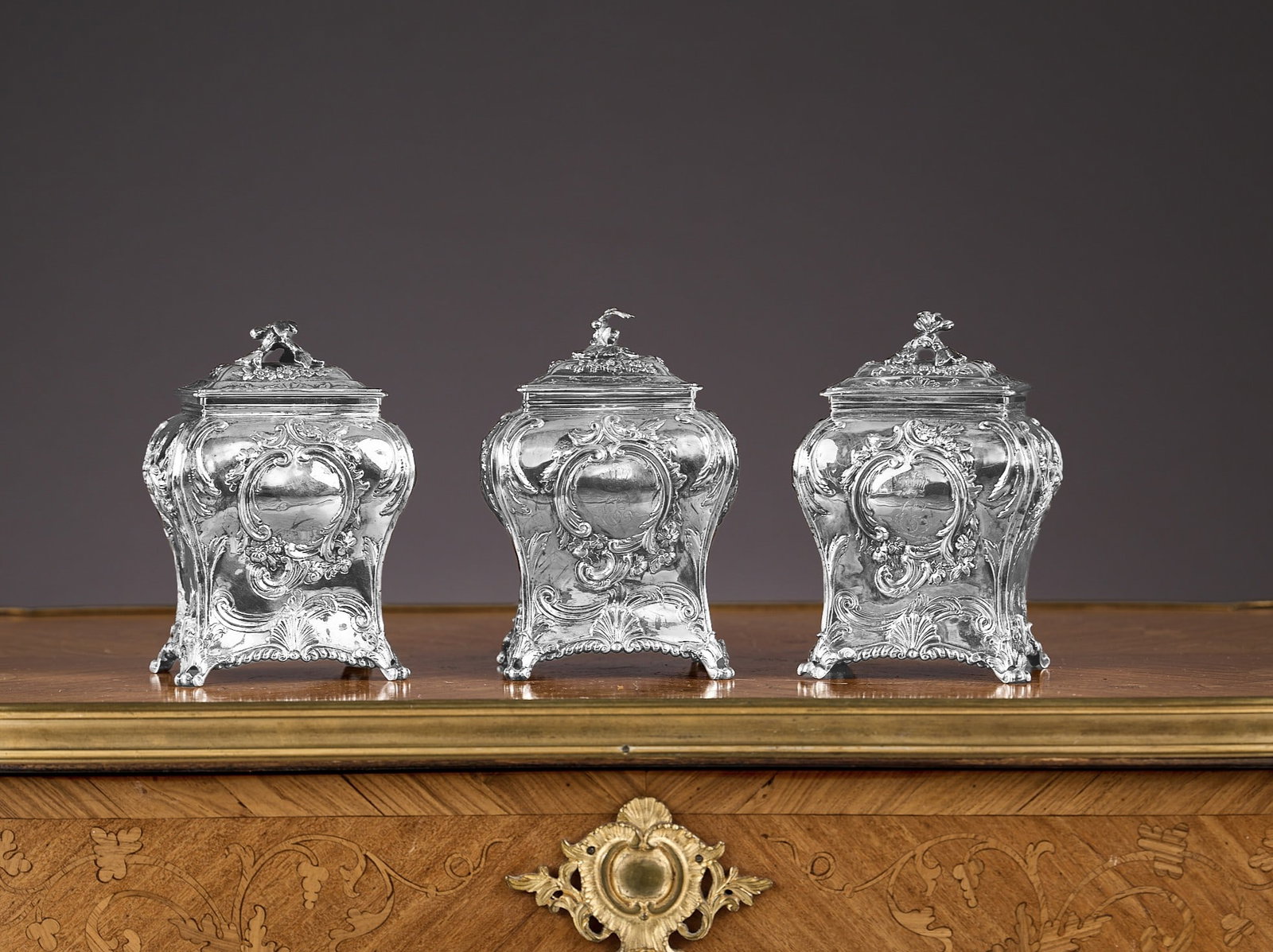 A SET OF THREE GEORGE III STERLING SILVER TEA CADDIES, LONDON, 1772, MARKS FOR EMICK ROMER: A SET OF THREE GEORGE III STERLING SILVER TEA CADDIES, LONDON, 1772, MARKS FOR EMICK ROMER the 18th century Georgian antique tea caddy set comprising one larger and a pair smaller, all with Rococo dec
