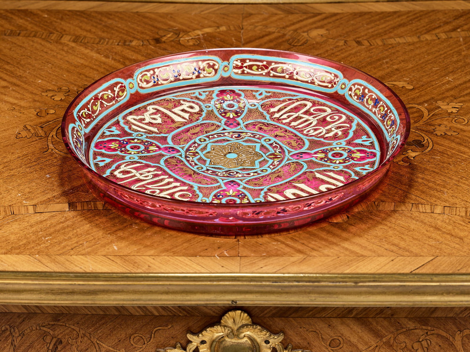 AN 'ARABIAN' STYLE ENAMELLED GLASS DISH IN THE MANNER OF P.J. BROCARD: AN 'ARABIAN' STYLE ENAMELLED GLASS DISH IN THE MANNER OF P.J. BROCARD the 20th century European circular dish with raised rim and recessed centre, decorated in the 'Arabian' style for the Middle Easte