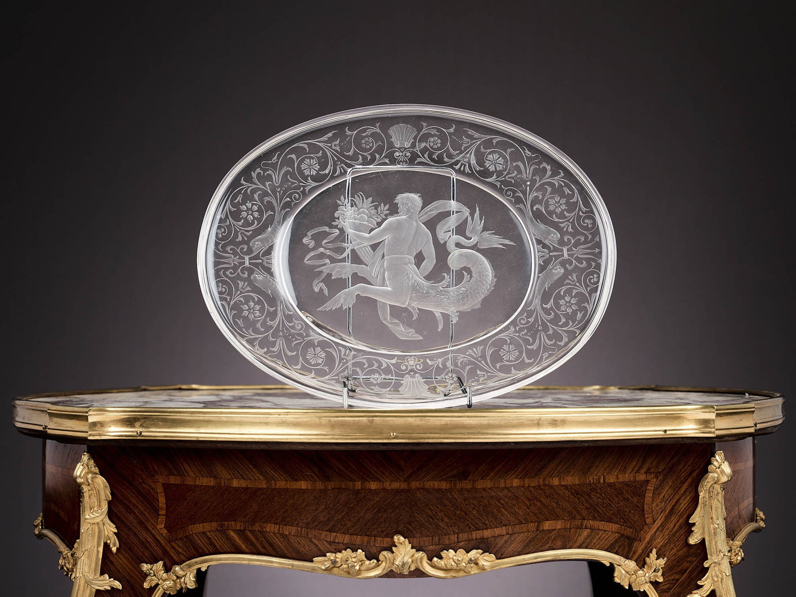 LOBMEYR: A FINE INTAGLIO ENGRAVED GLASS DISH DEPICTING TRITON, C. 1890: LOBMEYR: A FINE INTAGLIO ENGRAVED GLASS DISH DEPICTING TRITON, C. 1890 the late 19th century Austrian oval glass plate in the Renaissance style designed to resemble rock crystal, the centre with a mer