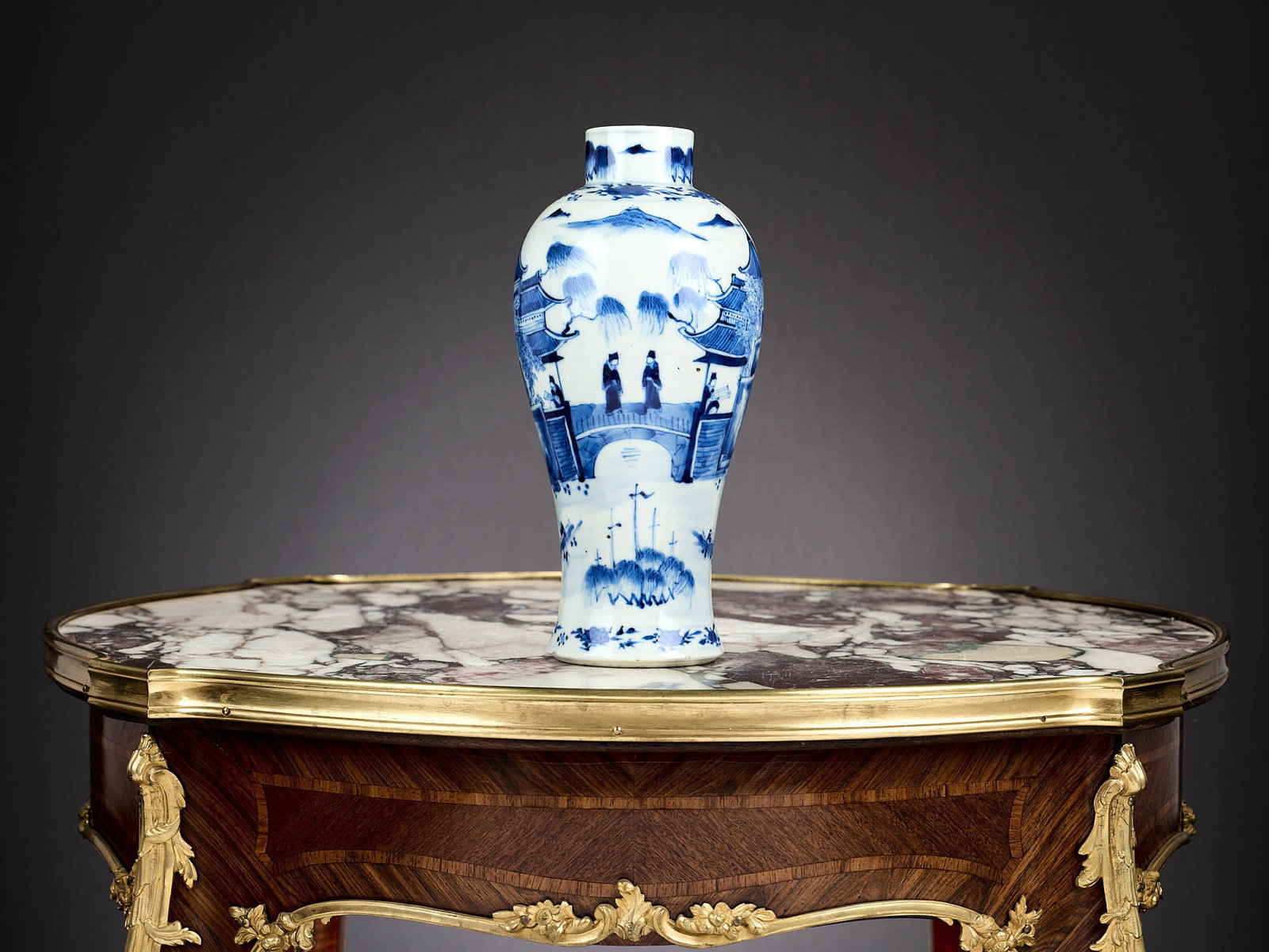 A CHINESE QING DYNASTY PORCELAIN BALUSTER VASE: A CHINESE QING DYNASTY PORCELAIN BALUSTER VASE decorated in blue and white with pagodas and figures, with a short cylindrical neck, with Kangxi style four charcter mark to underside, 23cm high