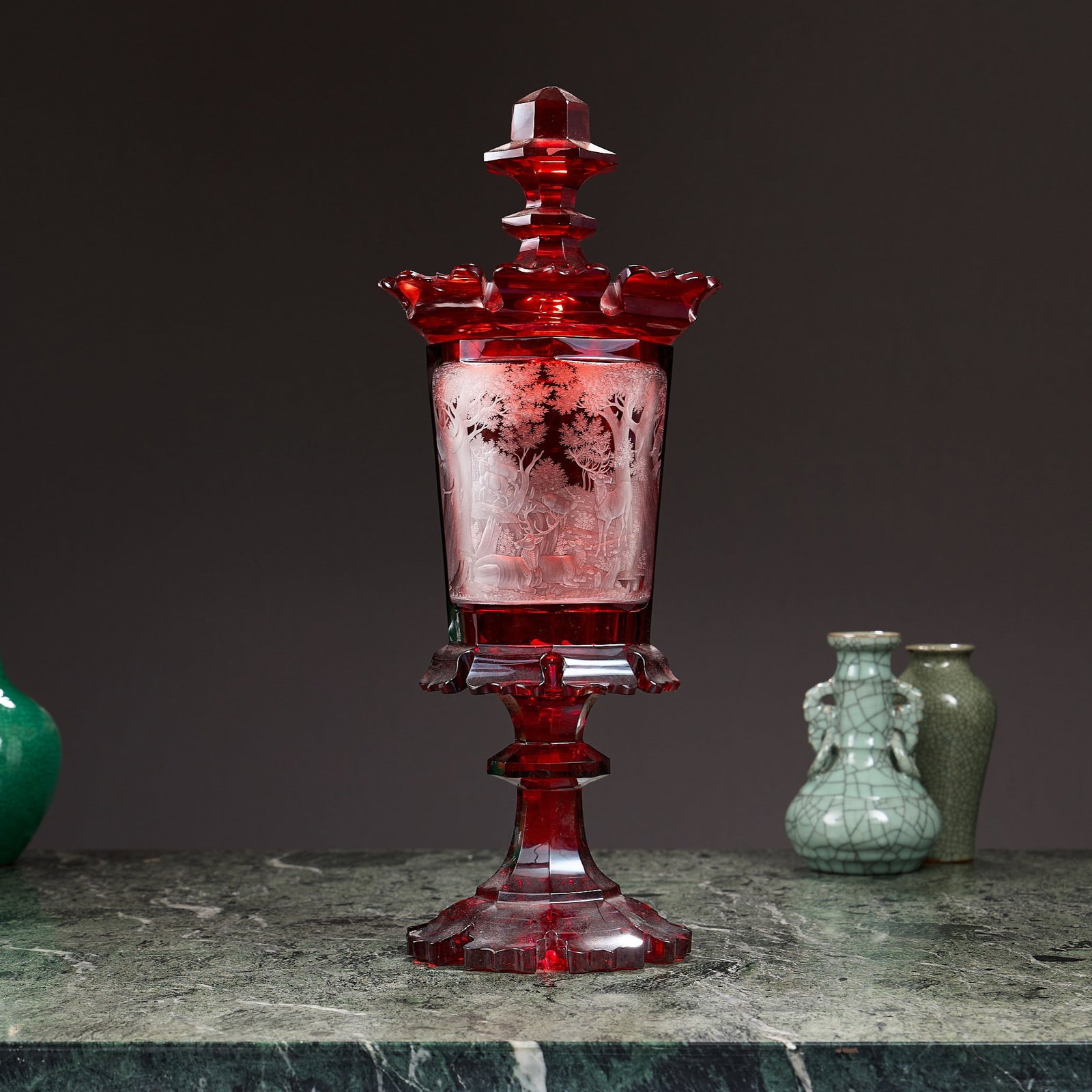 A FINE MID 19TH CENTURY BOHEMIAN RUBY STAINED AND ENGRAVED GLASS VASE AND COVER: A FINE MID 19TH CENTURY BOHEMIAN RUBY STAINED AND ENGRAVED GLASS VASE AND COVER the large goblet and cover with faceted pagoda shaped cover, the tapering octagonal shaped body engraved with a scene of