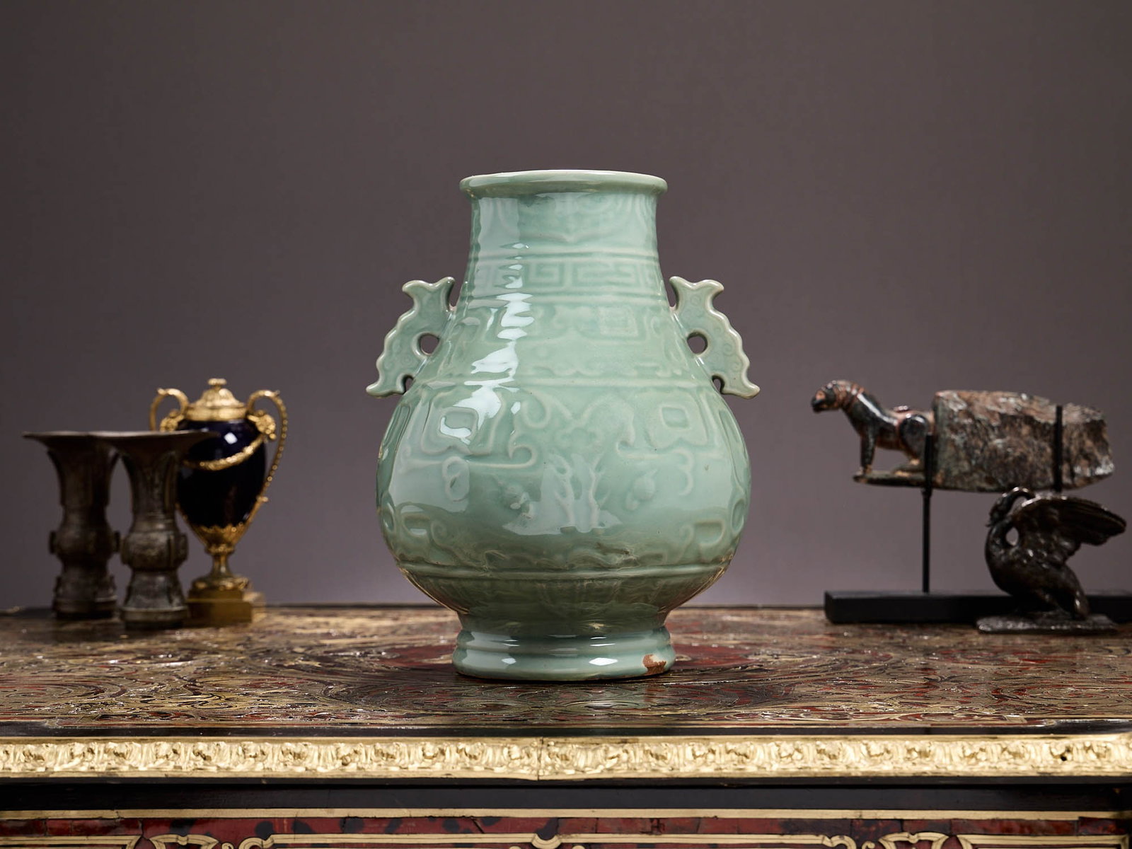 A CHINESE QING DYNASTY CELADON PORCELAIN VASE: A CHINESE QING DYNASTY CELADON PORCELAIN VASE of baluster form, with applied dragon handles and with archaistic style relief decoration to the body, on a ringed, circular foot, unmarked, drilled to ba