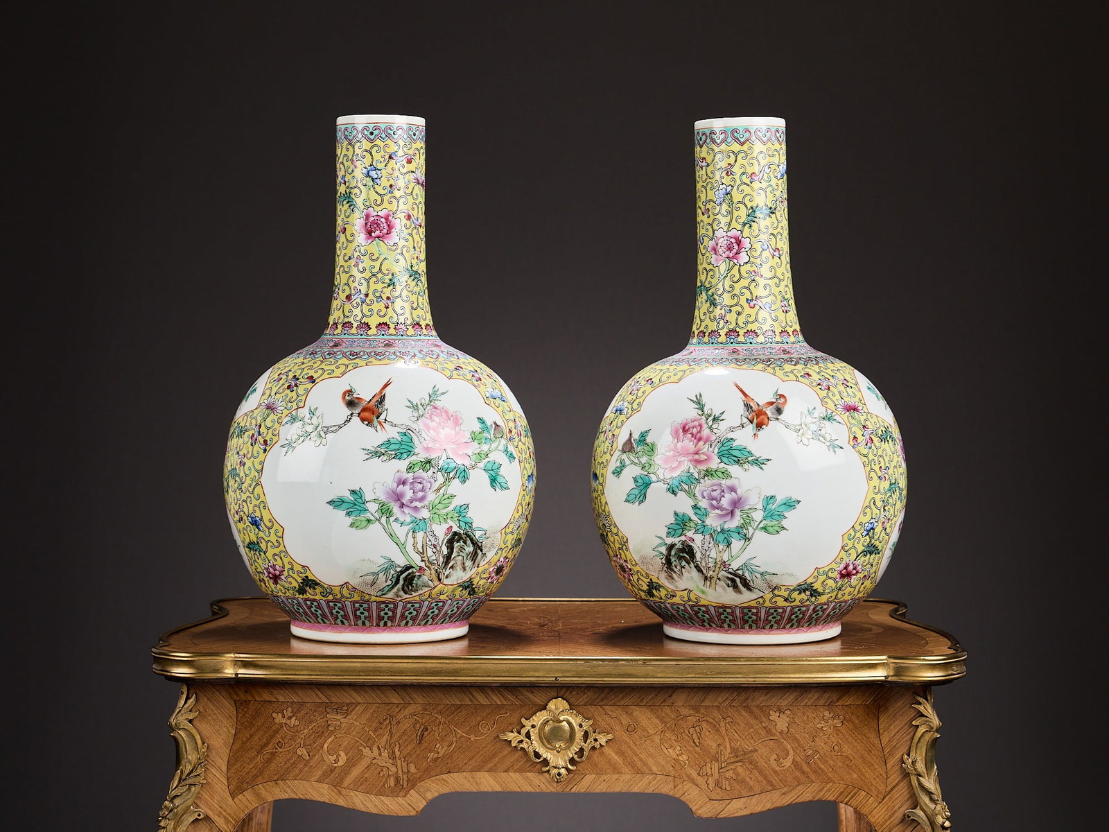 A PAIR OF CHINESE FAMILLE ROSE PORCELAIN VASES: A PAIR OF CHINESE FAMILLE ROSE PORCELAIN VASES the bottle shaped vase decorated in the Qianlong style, with white panels on a yellow ground, the panels enclosing birds and flowers, marked to underside