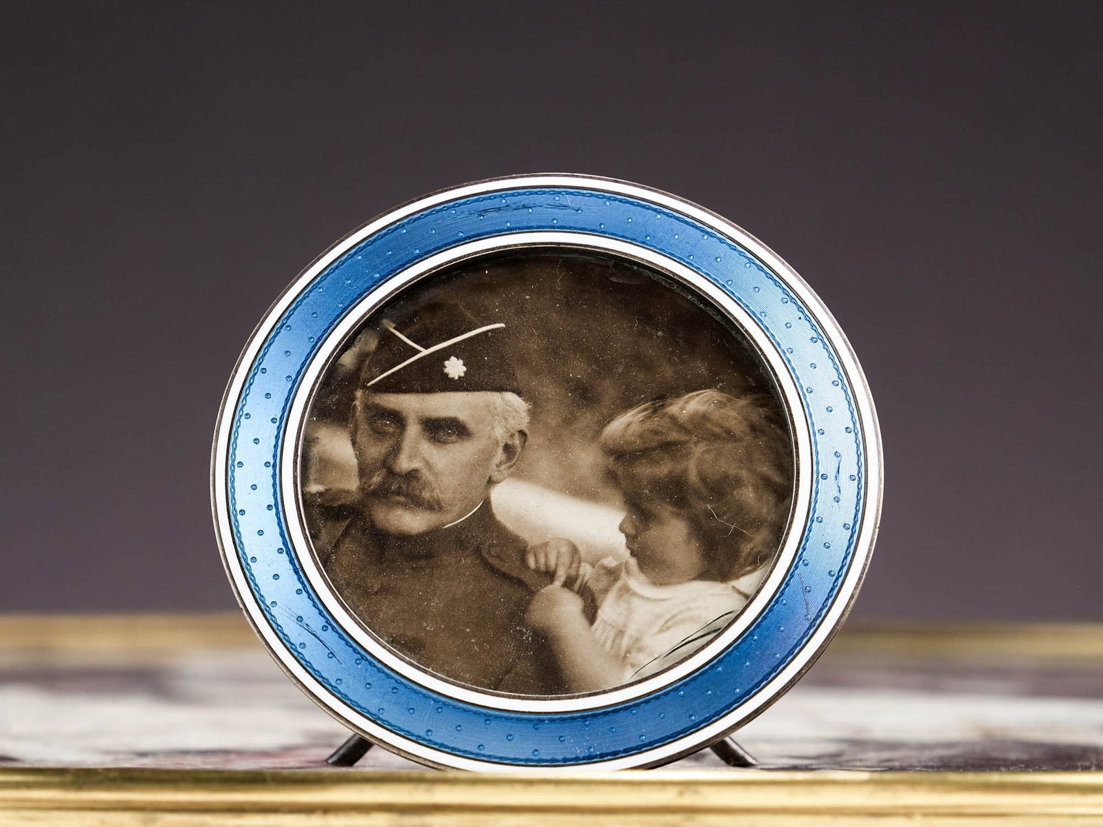 AN EARLY 20TH CENTURY FRENCH SILVER AND ENAMEL PHOTOGRAPH FRAME: AN EARLY 20TH CENTURY FRENCH SILVER AND ENAMEL PHOTOGRAPH FRAME circa 1900, of circular form with a band of translucent light blue enamel with spotted decoration within a white border, glazed, with ea