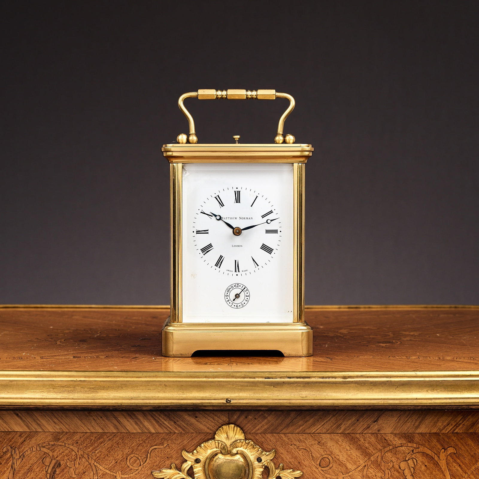A MATTHEW NORMAN GILT BRASS STRIKING CARRIAGE CLOCK WITH ALARM AND REPEAT: A MATTHEW NORMAN GILT BRASS STRIKING CARRIAGE CLOCK WITH ALARM AND REPEAT the corniche case with handle over, the white enamelled dial with Roman numerals, signed 'MATTHEW NORMAN LONDON', with subsidi