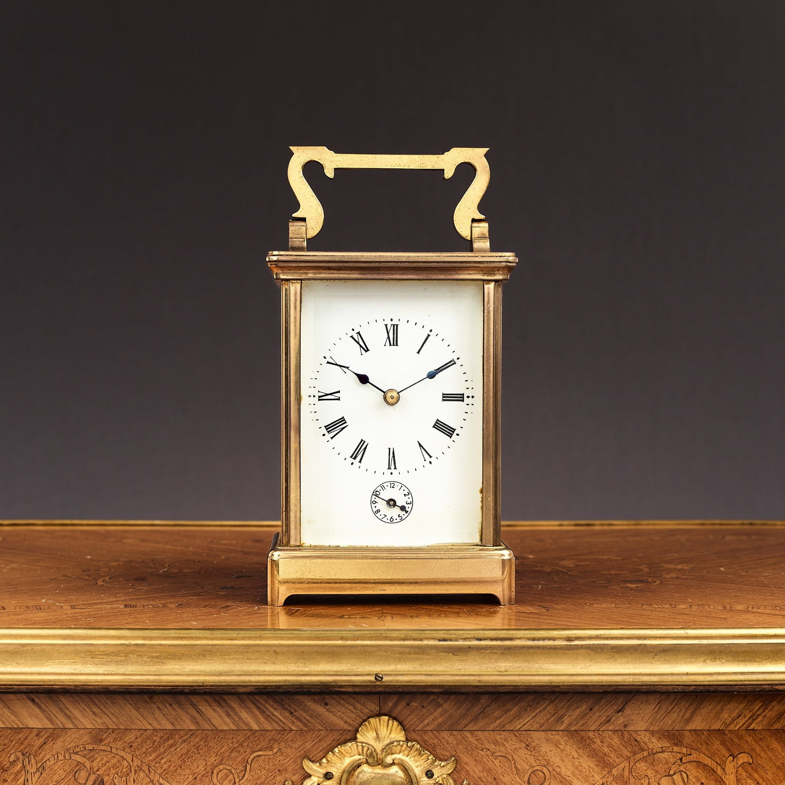 A FRENCH LACQUERED BRASS STRIKING CARRIAGE CLOCK WITH ALARM: A FRENCH LACQUERED BRASS STRIKING CARRIAGE CLOCK WITH ALARM 20th century, with swing handle over, the white enamelled dial with Roman numerals and subsidiary alarm dial below, with lever platform esca