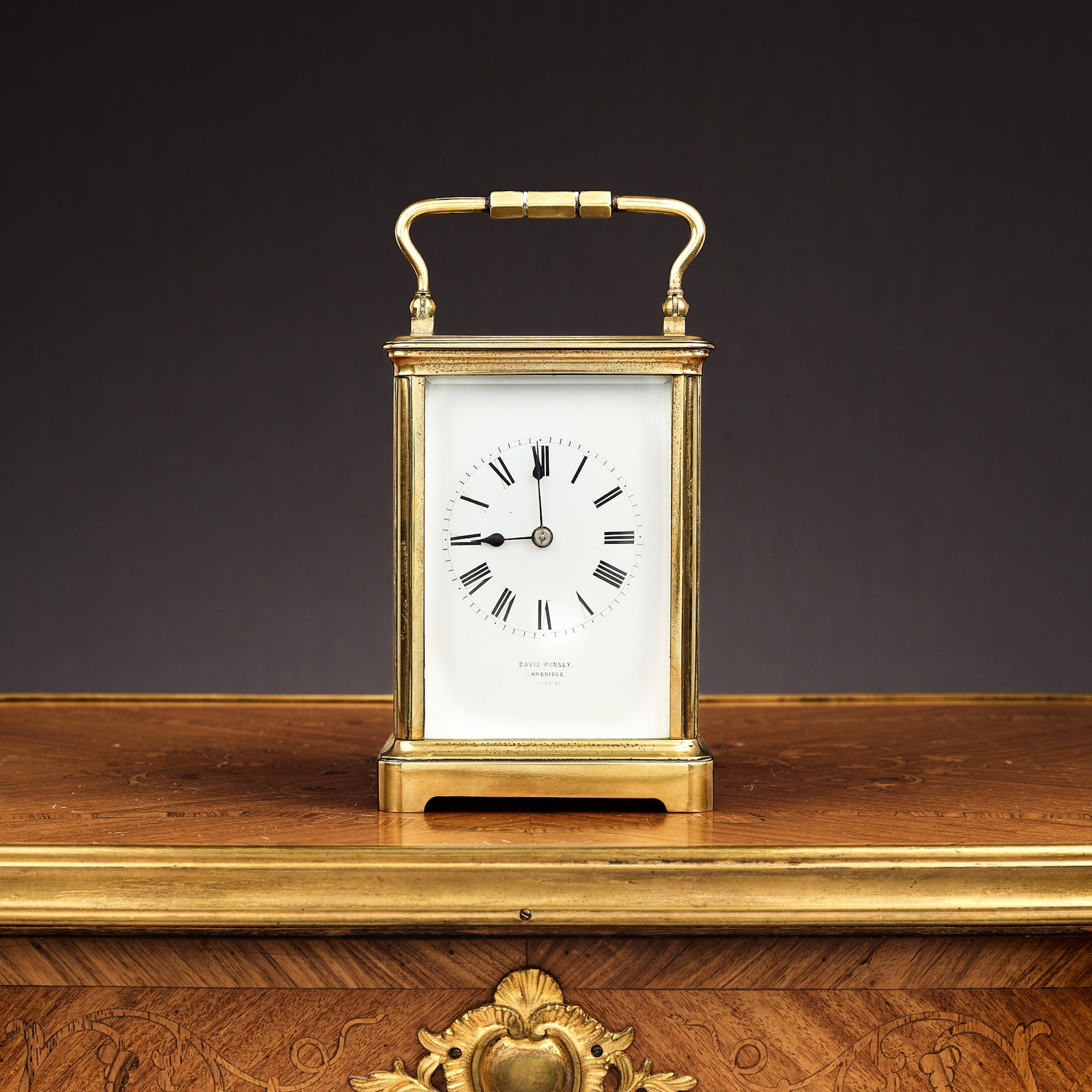 A LATE 19TH CENTURY LACQUERED BRASS STRIKING CARRIAGE CLOCK: A LATE 19TH CENTURY LACQUERED BRASS STRIKING CARRIAGE CLOCK the corniche case enclosing the white enamelled dial with Roman numerals, signed with retailer mark 'David Munsey Cambridge', with lever pla