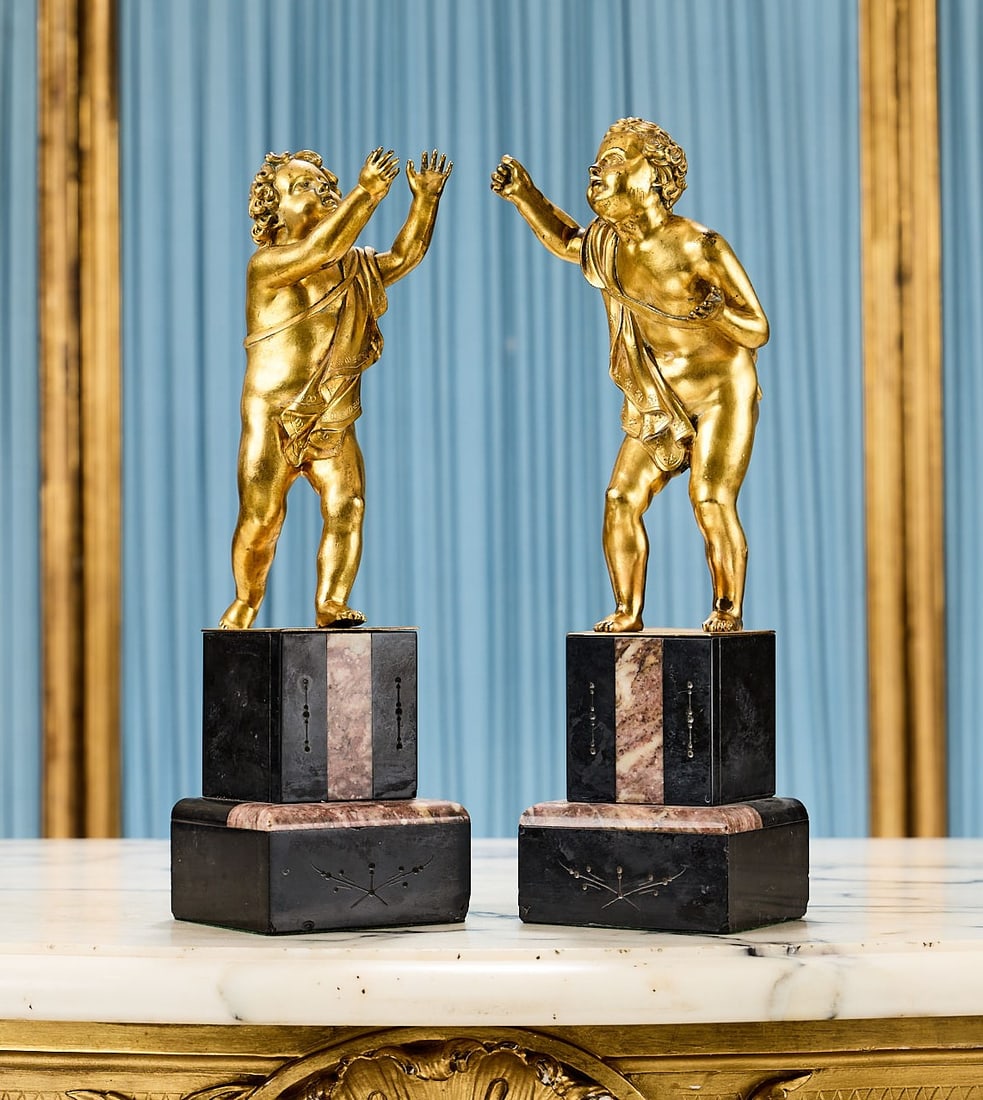 A PAIR OF 19TH CENTURY GILT BRONZE FIGURES OF BAROQUE PUTTI: A PAIR OF 19TH CENTURY GILT BRONZE FIGURES OF BAROQUE PUTTI in the manner of Bernini, the cherubs each with carefully delineated, curly hair with chisled detail, both gesticulating upwards, mounted on