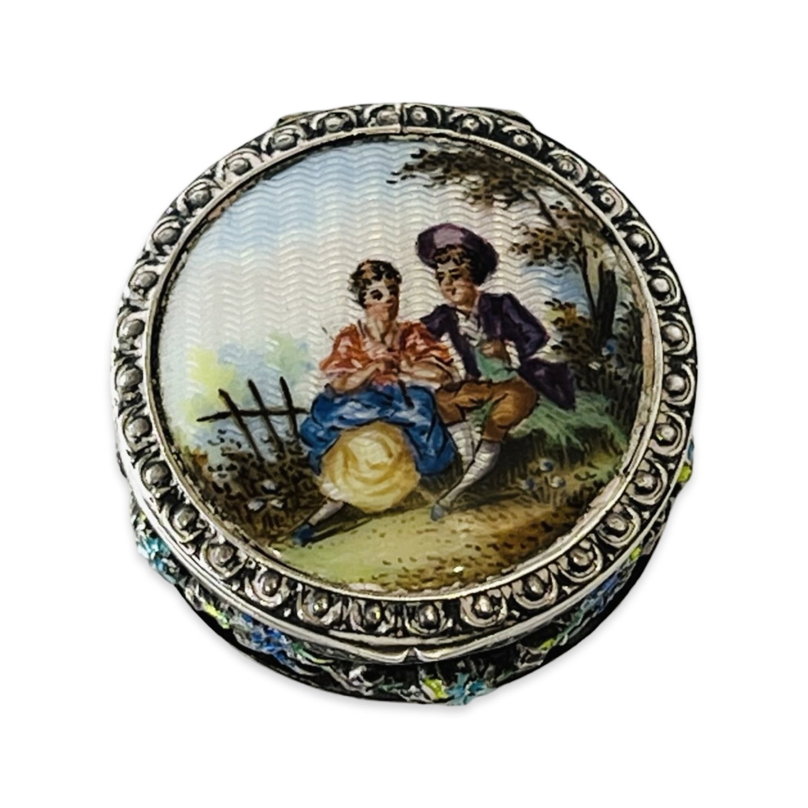 A LATE 19TH CENTURY VIENNESE SILVER AND ENAMELLED PILL BOX: A LATE 19TH CENTURY VIENNESE SILVER AND ENAMELLED PILL BOX Vienna, Austrian, of circular form, the cover with translucent enamel scene of lovers in a landscape, the sides with applied polychrome ename