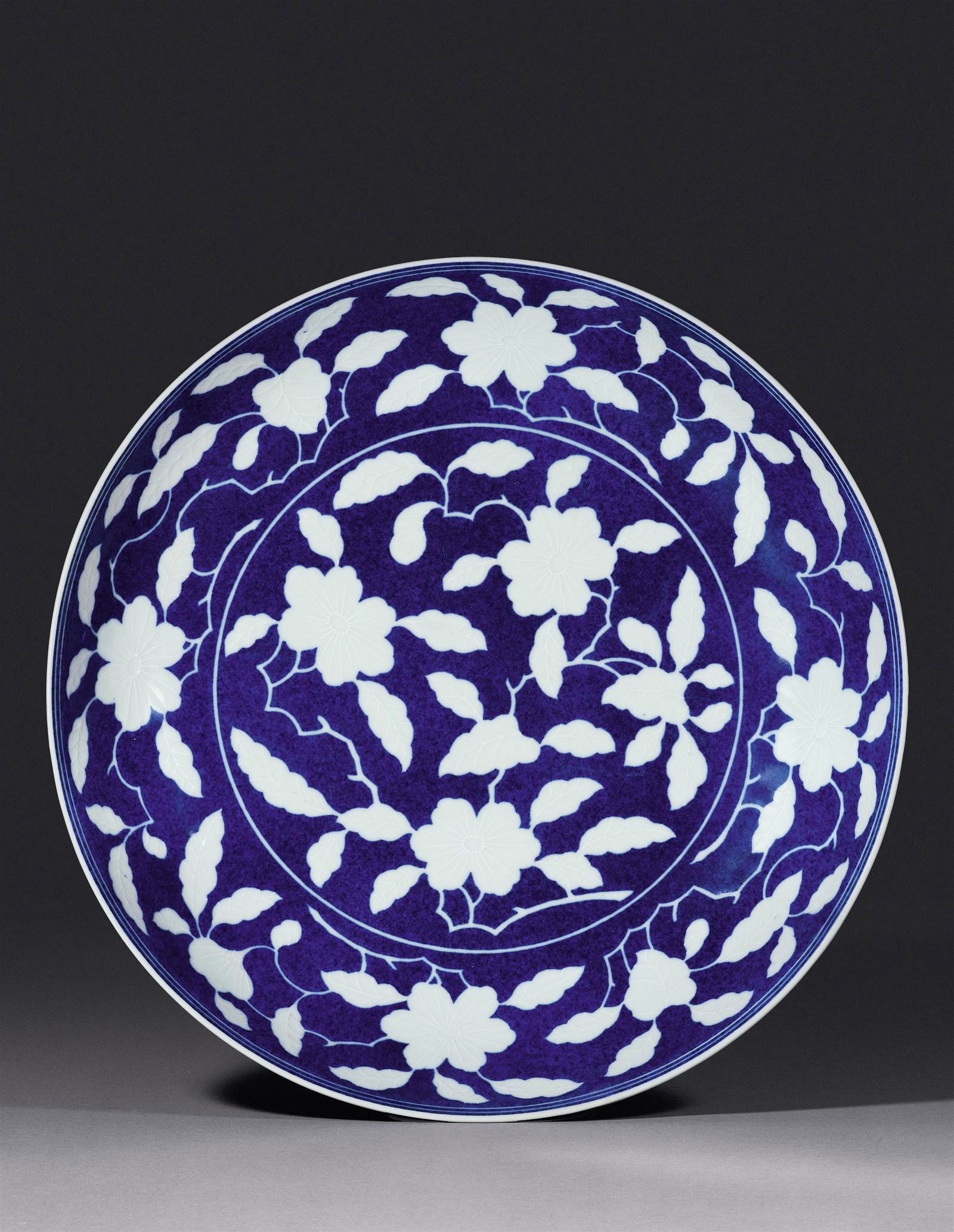 A LARGE SPLASHED-BLUE GROUND DISH WITH FLORAL MOTIFS (1 of 2)