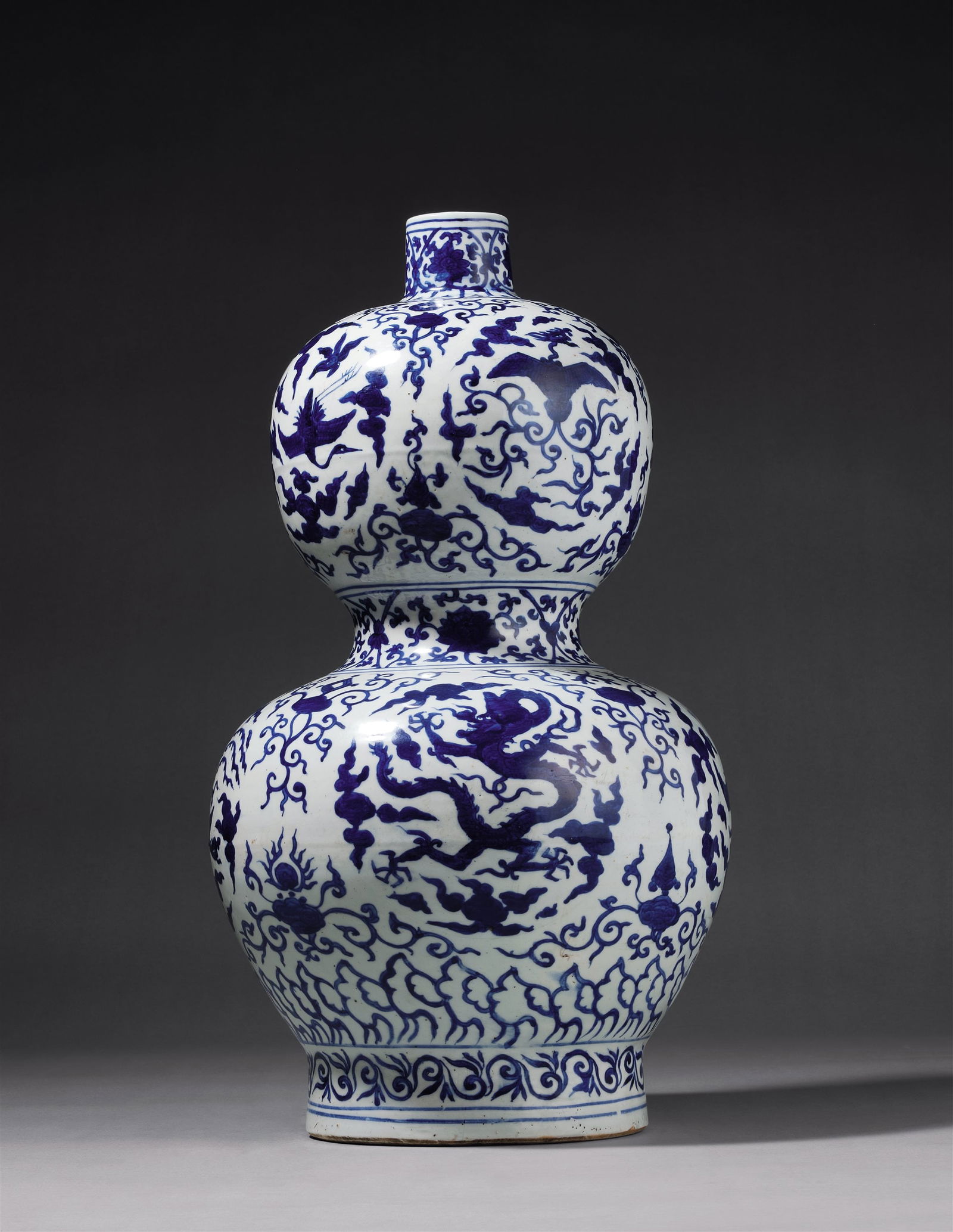 A BLUE-AND-WHITE GOURD VASE WITH DRAGON, CRANE AND PHOENIX: Mark and Period of Jiajing, Ming Dynasty