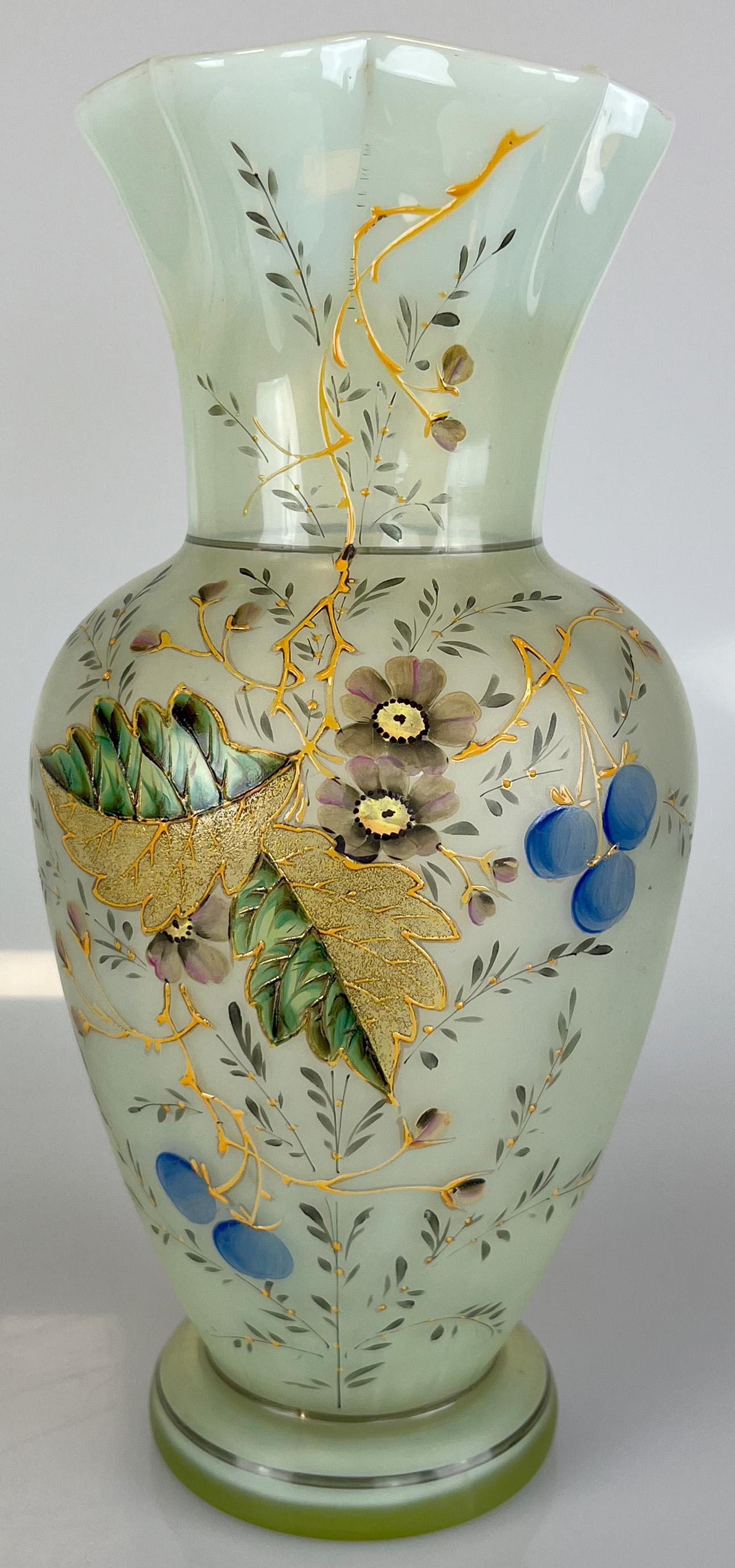 Opalglas-Uranglasvase, wohl Böhmen, um 1900. An opal glass uranium vase, probably Bohemia,: Circa 27 cm hoch. Balusterform mit gewelltem Hals. Dekoriert auf Schauseite mit Emailleblumen und Blättern sowie Goldzier. Am Fuß restauriert. Zustand siehe Fotos. Approx. 27 cm (height). Ba