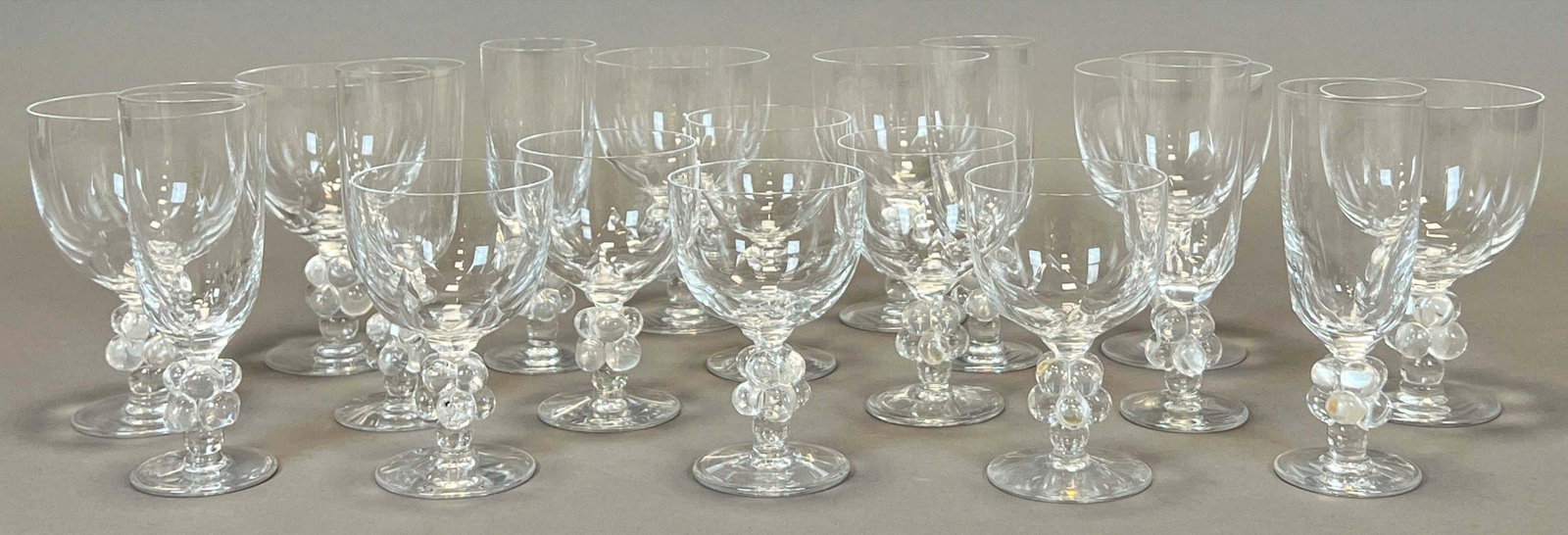 Großes Konvolut von 18 Gläsern. Lalique. "Clos Vougeot". - Large set of 18 glasses.: Frankreich. 2. Hälfte 20. Jahrhundert. Mit Traubendekor. 6x Rotweingläser. Circa 15,5 cm hoch. 6x Sektgläser. Je circa 17,5 cm hoch und 6x Weissweingläser. Circa 13,5 cm hoch. Unte