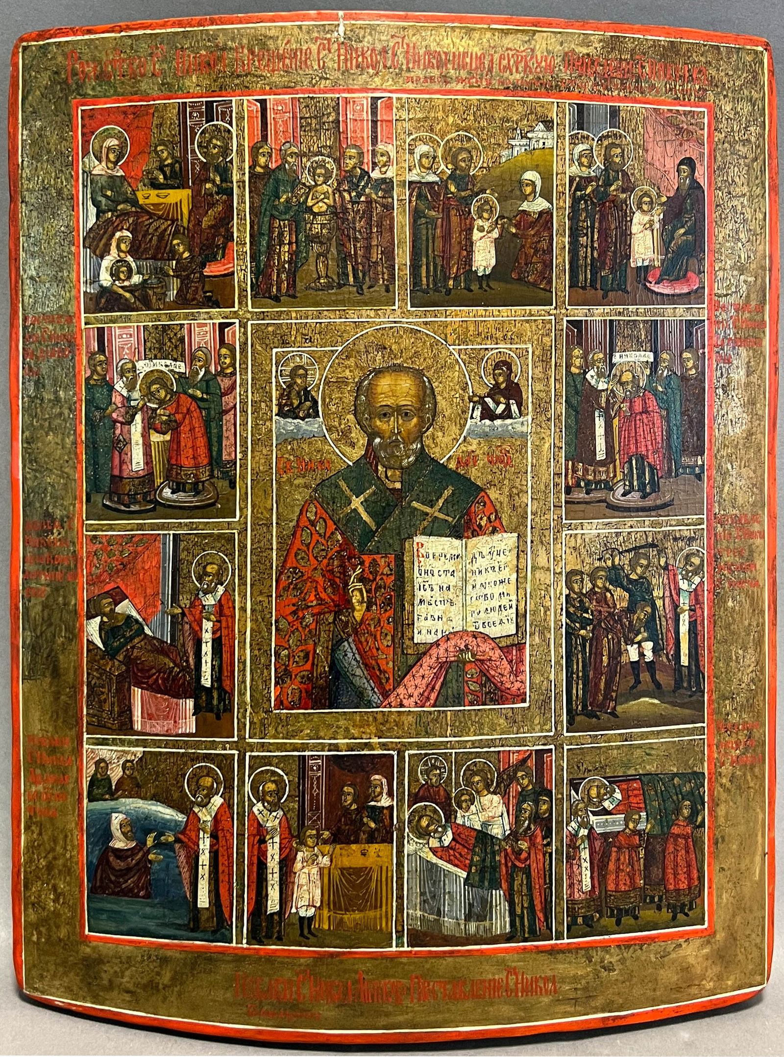 Icon. St. Nicholas and the scenes from his life. Russia. 19th century.: Circa 33 cm x 26,5 cm. Tempera painting on wood. Depiction of St. Nicholas with 12 most important stations of his life. Scratched / inscribed illegibly in Cyrillic on the reverse. Craquelé. Scrat