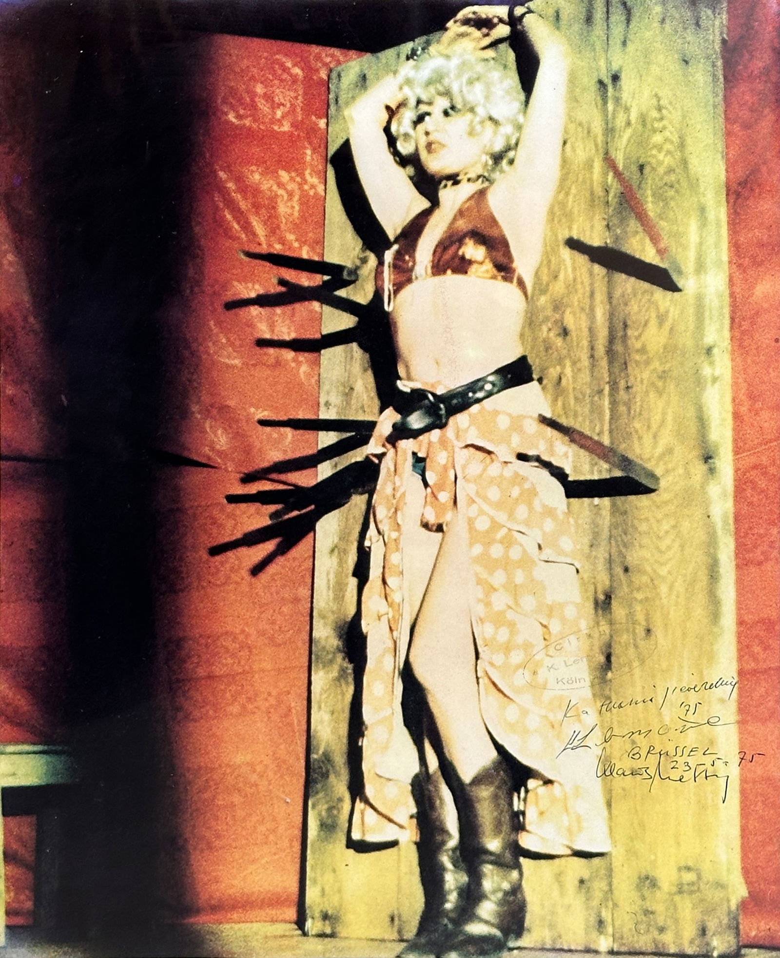 Kaka LEMOINE & Katharina SIEVERDING (XX-XXI) . Poster. "Show". 1975.: Approx. 35.5 cm x 28.5 cm. Circa 59.5 cm x 35.5 cm with frame. Poster by Katharina Sieverding of the offset reproduced photograph of a lady in cowboy boots (Kaka Lemoine), showing the target of the kn